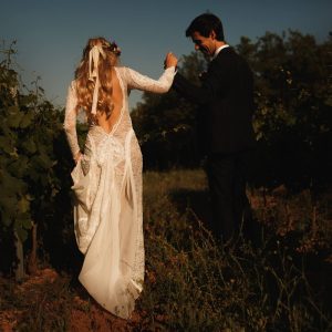 Bride and groom walking together in field France wedding