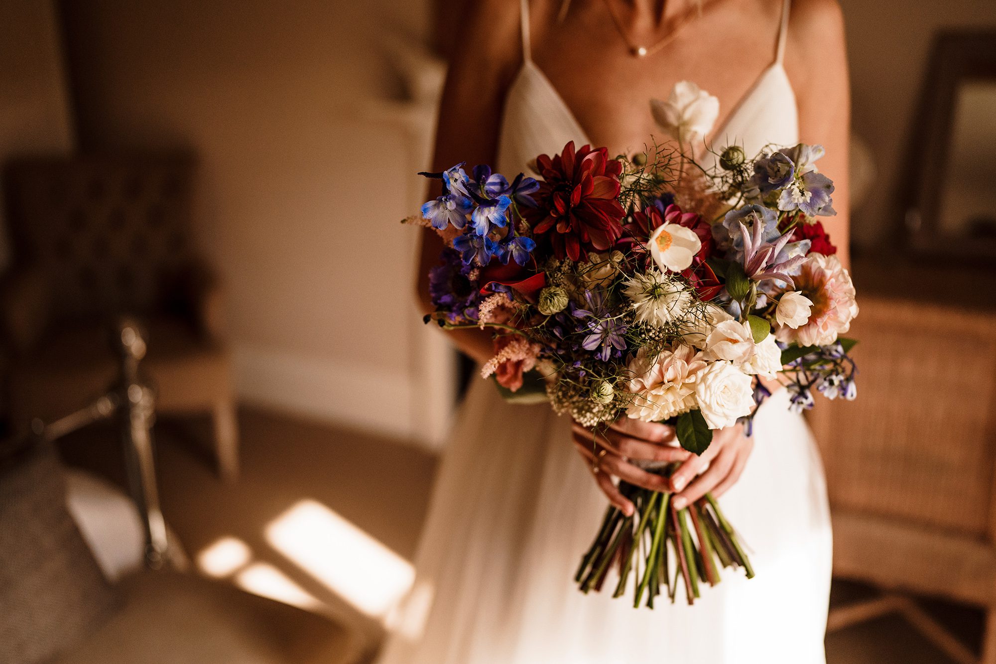 Bride clutches wildflower bouquet at Primrose Hill Farm wedding.