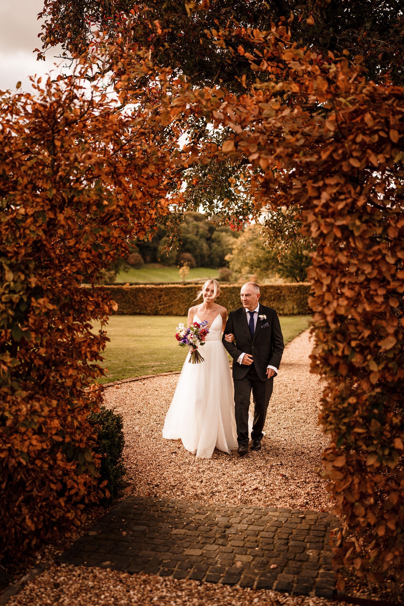 Father and daughter link arms in the beautiful Oxfordshire countryside.