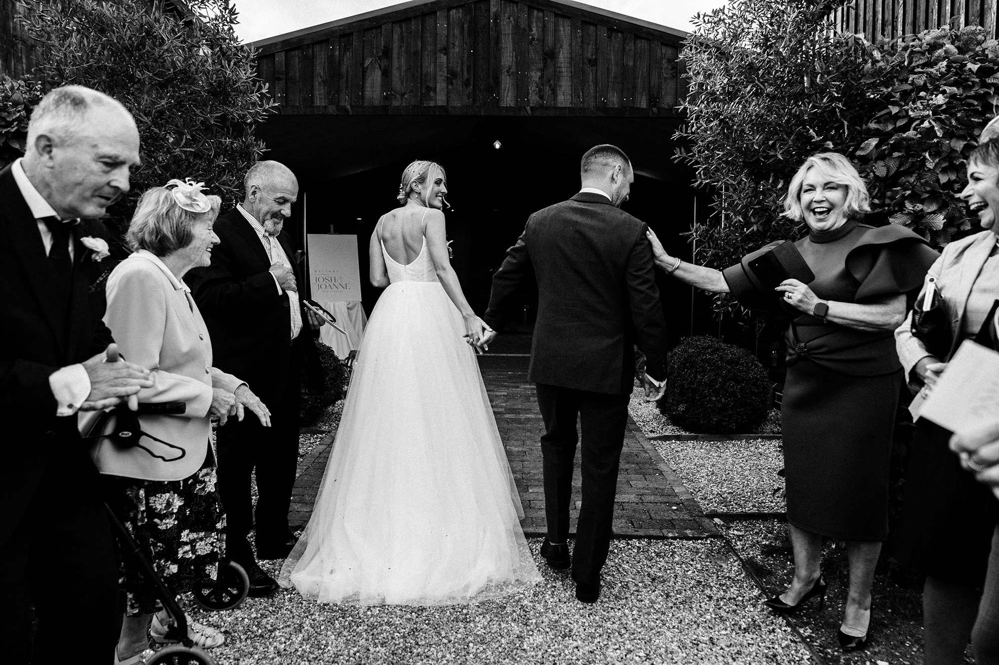 A hand of reassurance on the shoulder of the groom as he and his wife make their way into the reception at Primrose hill Farm.