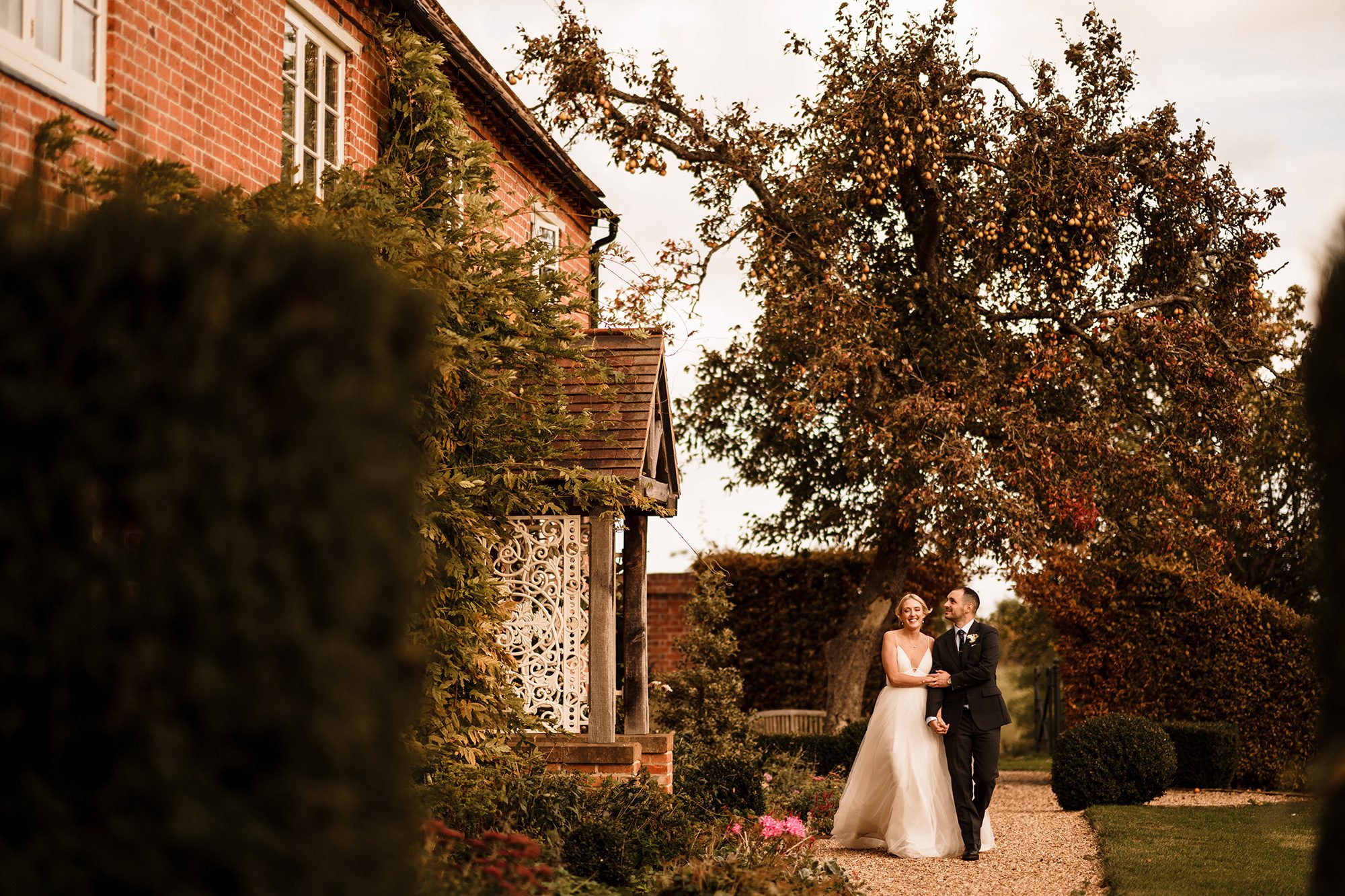 Weeding couple share a happy stroll beside the Primrose Hill Farm cottage.