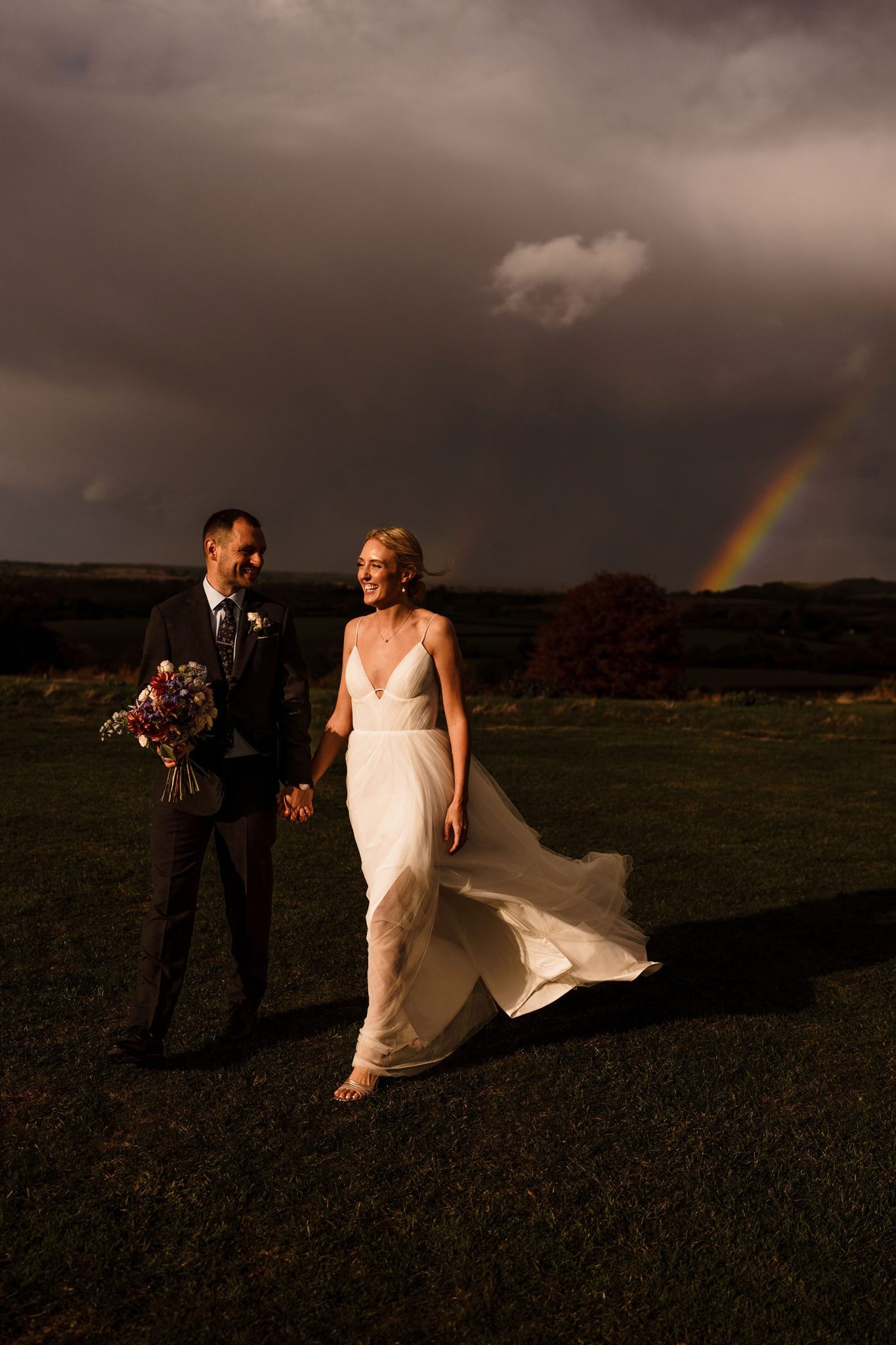 Bride and Groom walk to the end of a rainbow.