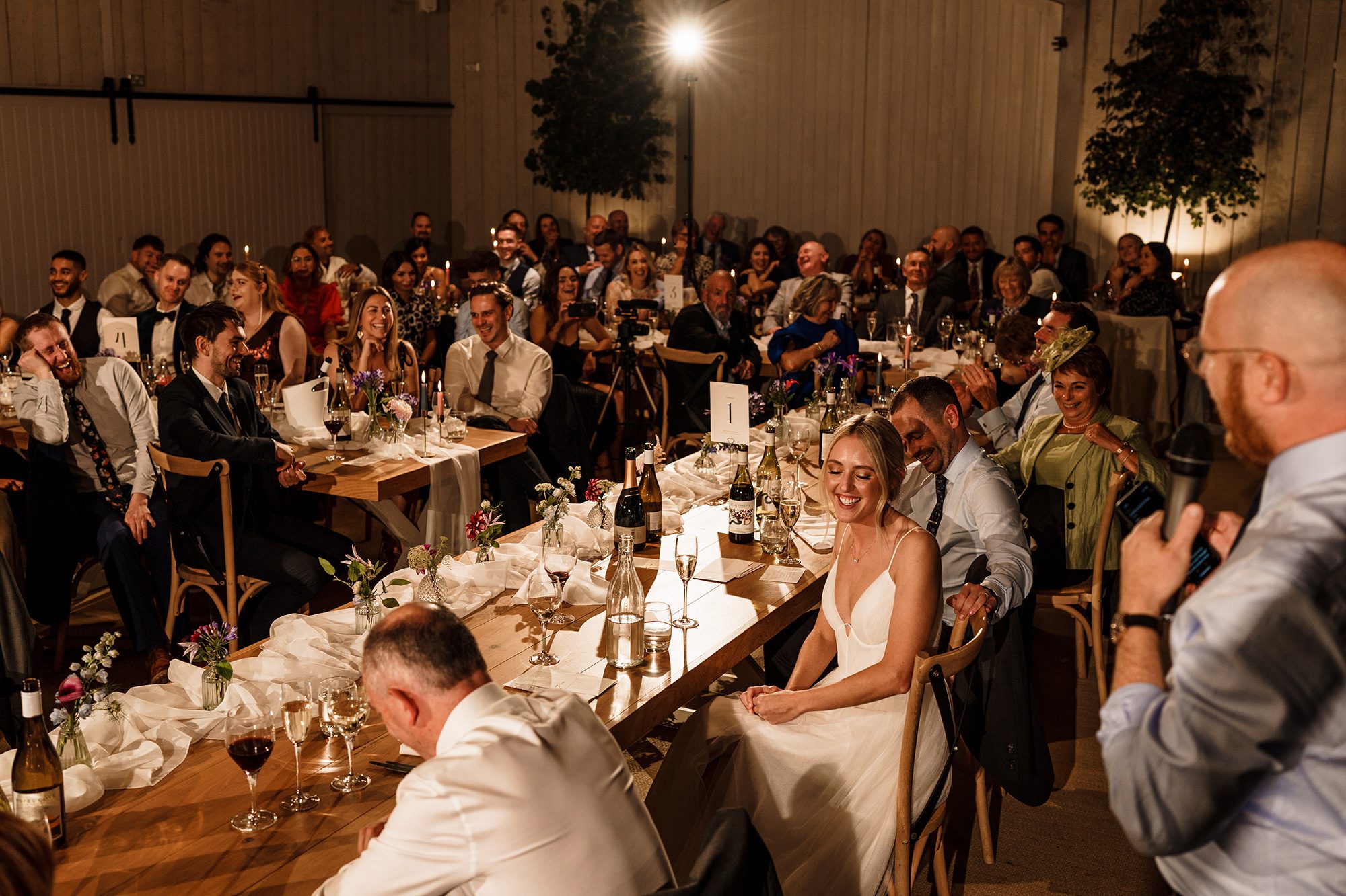Happy crowd listening to best mans speech at Primrose Hill Farm wedding reception.
