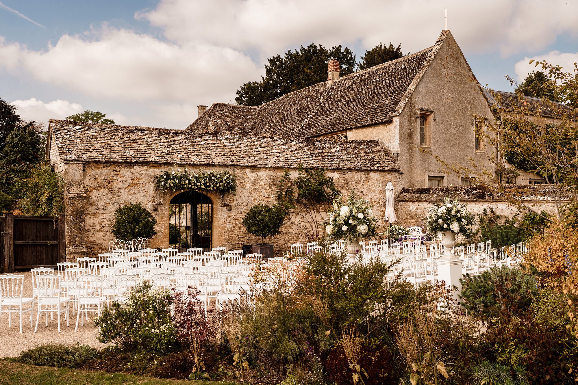 outdoor ceremony set up with white chairs in Oxfordshire