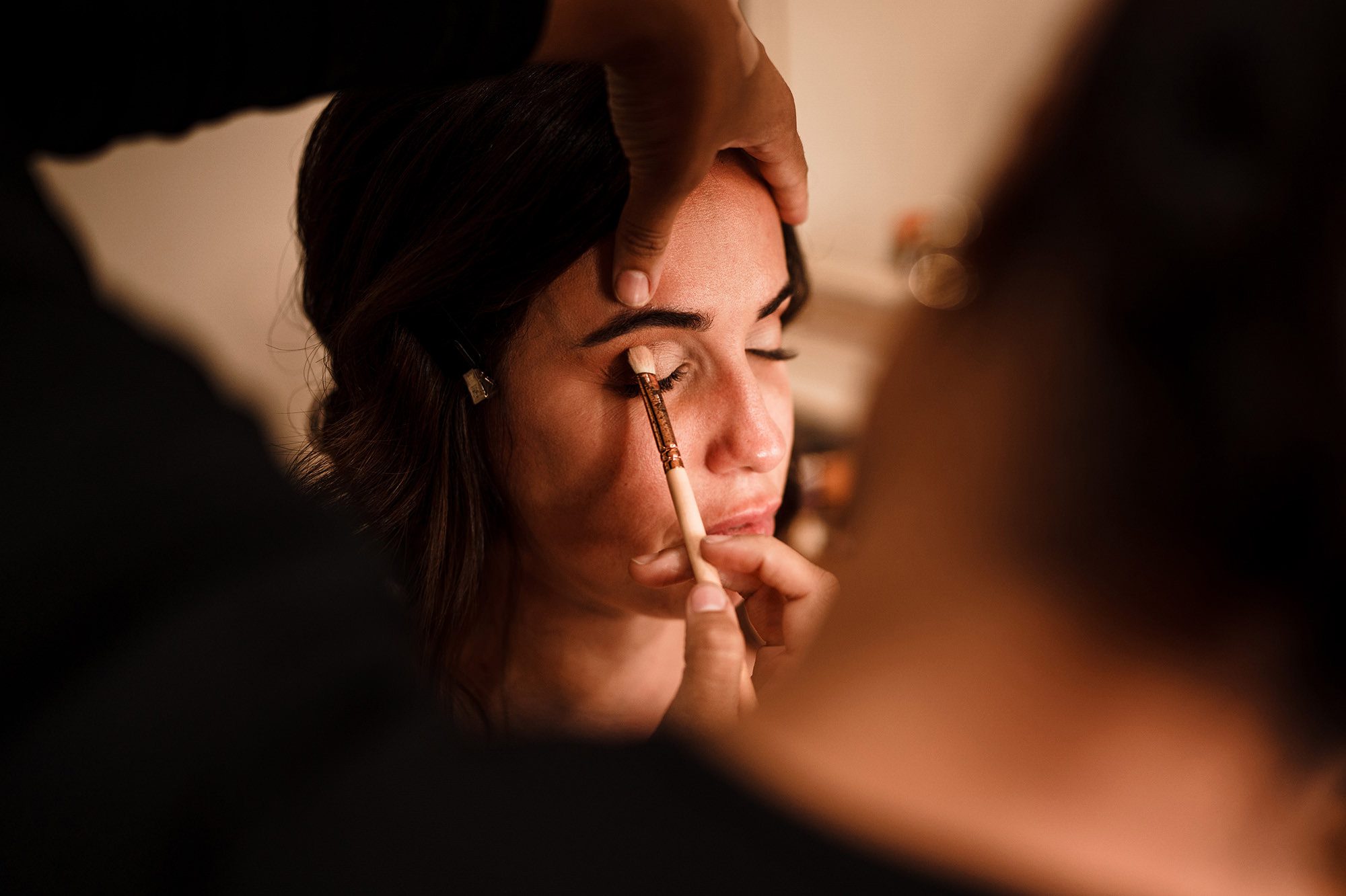 bride having makeup applied with brush at Caswell House bridal suite