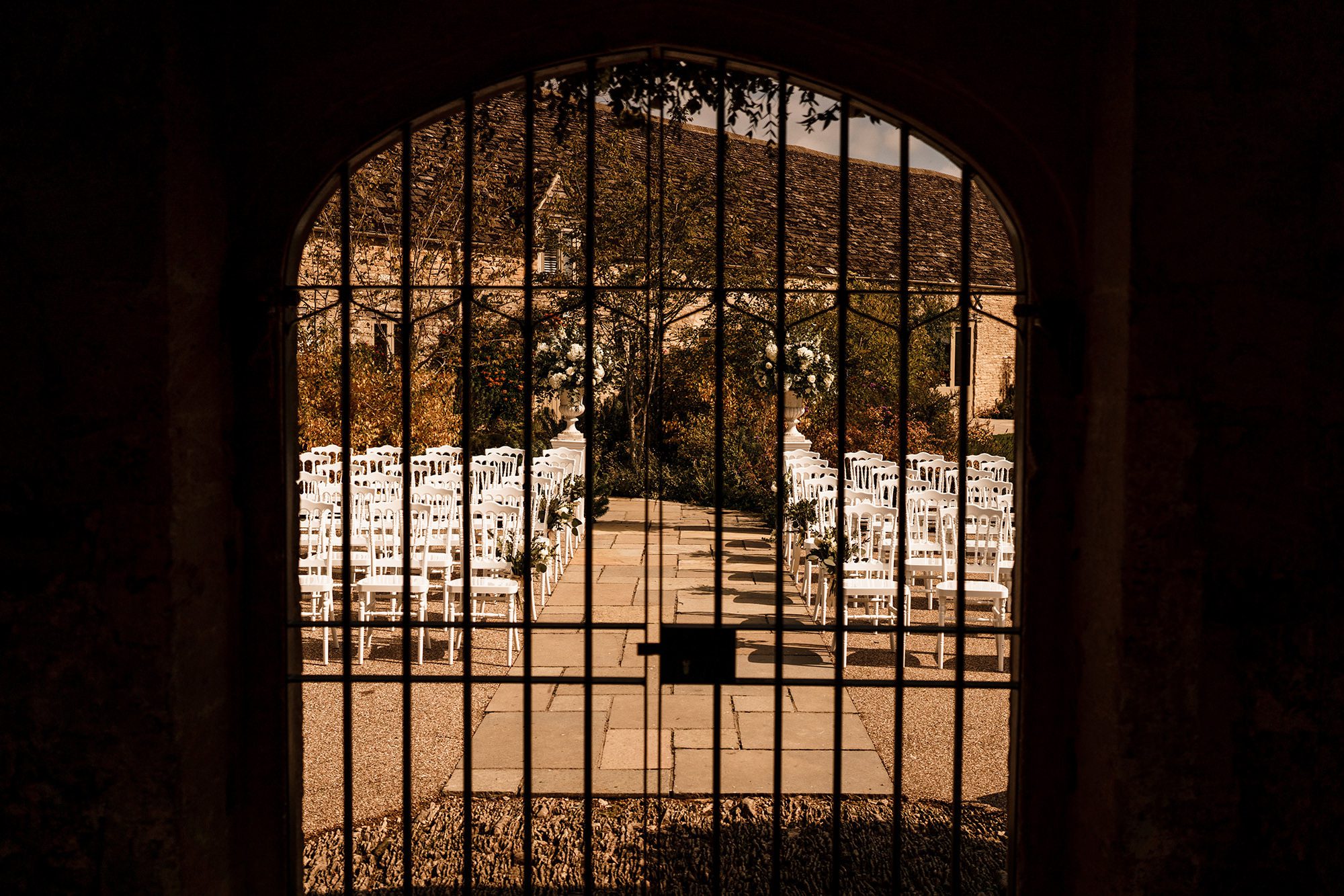 view through iron gates of chairs at Caswell House
