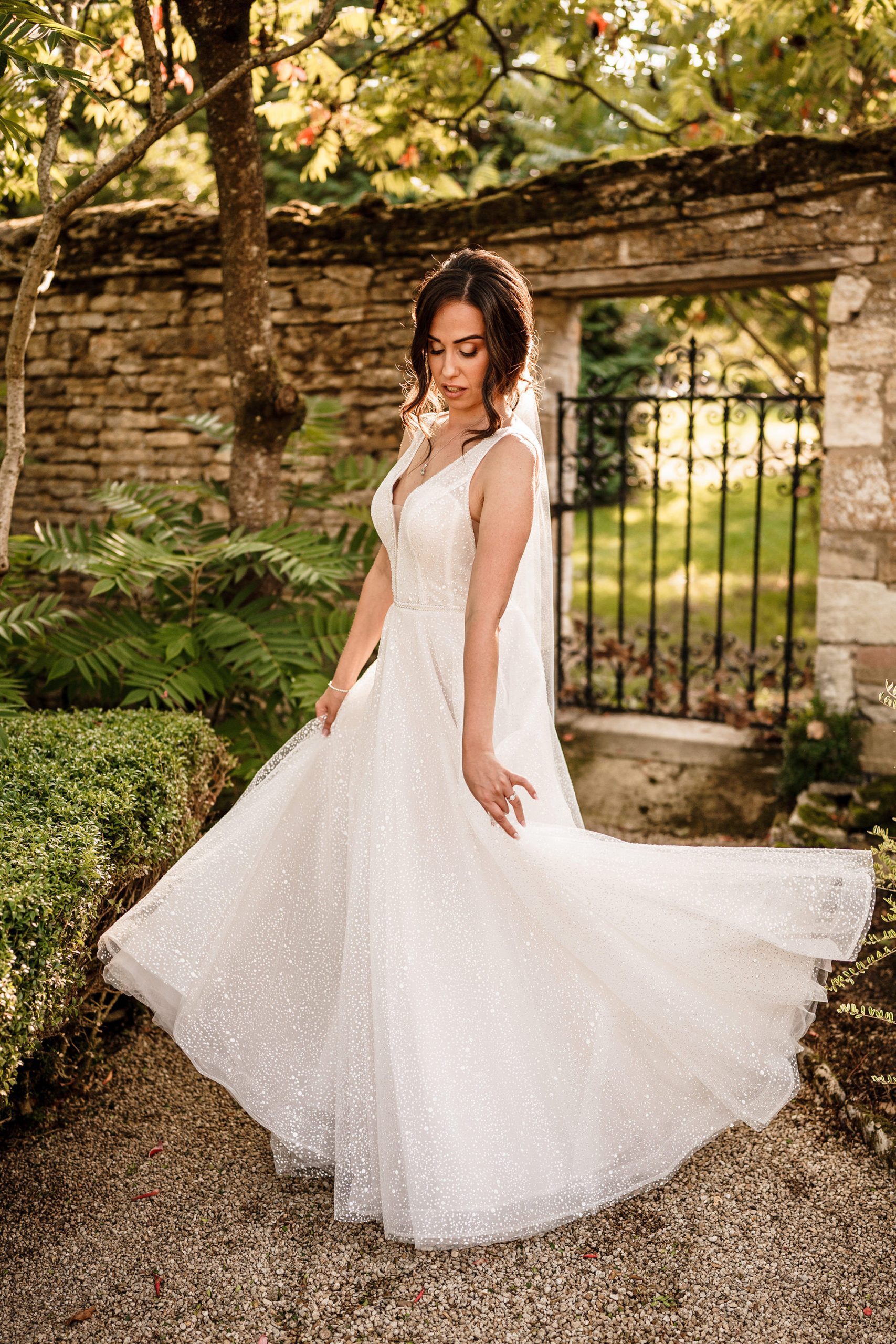bride dances in her dress in the Caswell House walled garden