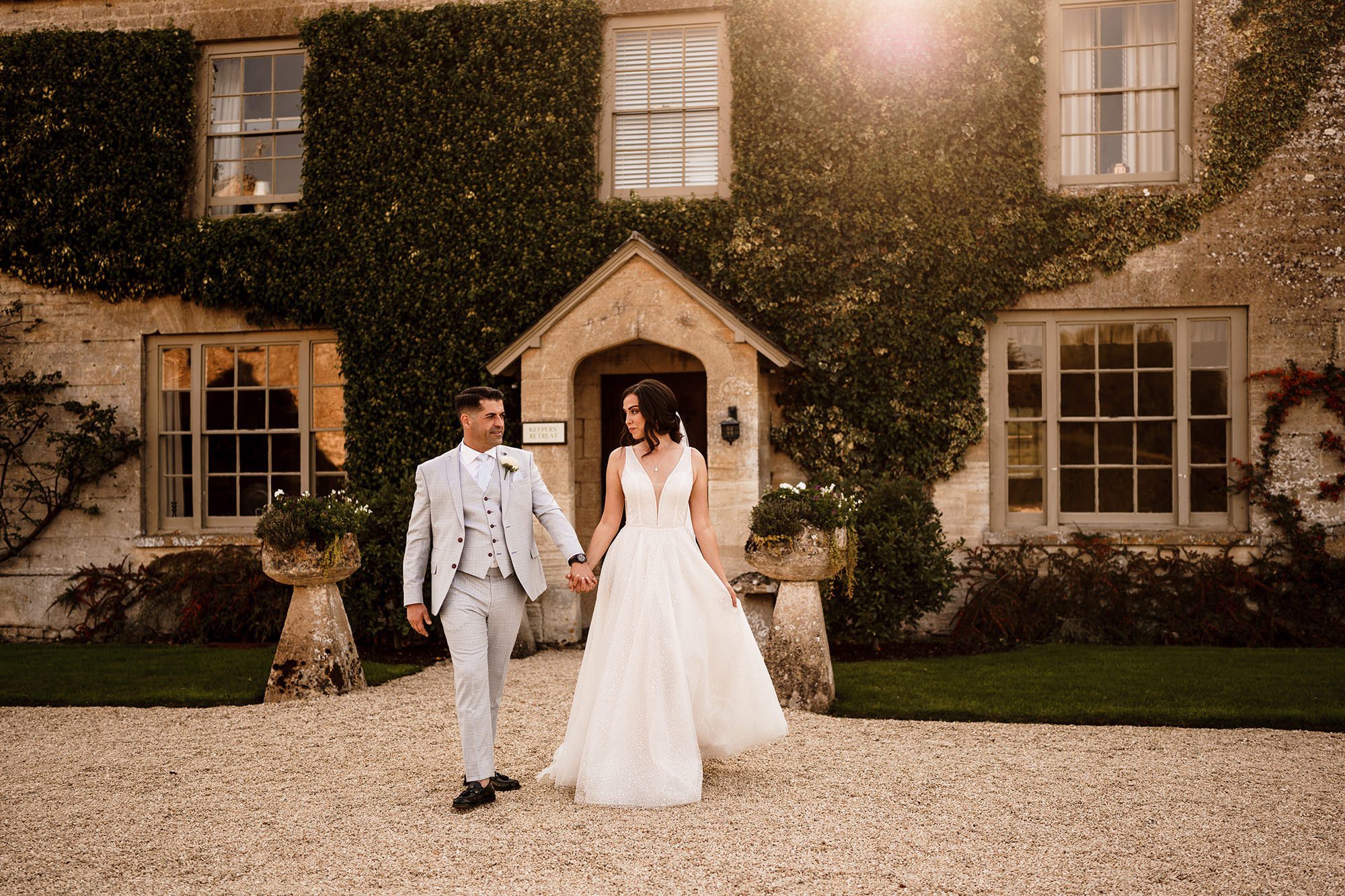 cotswolds house behind bide and groom