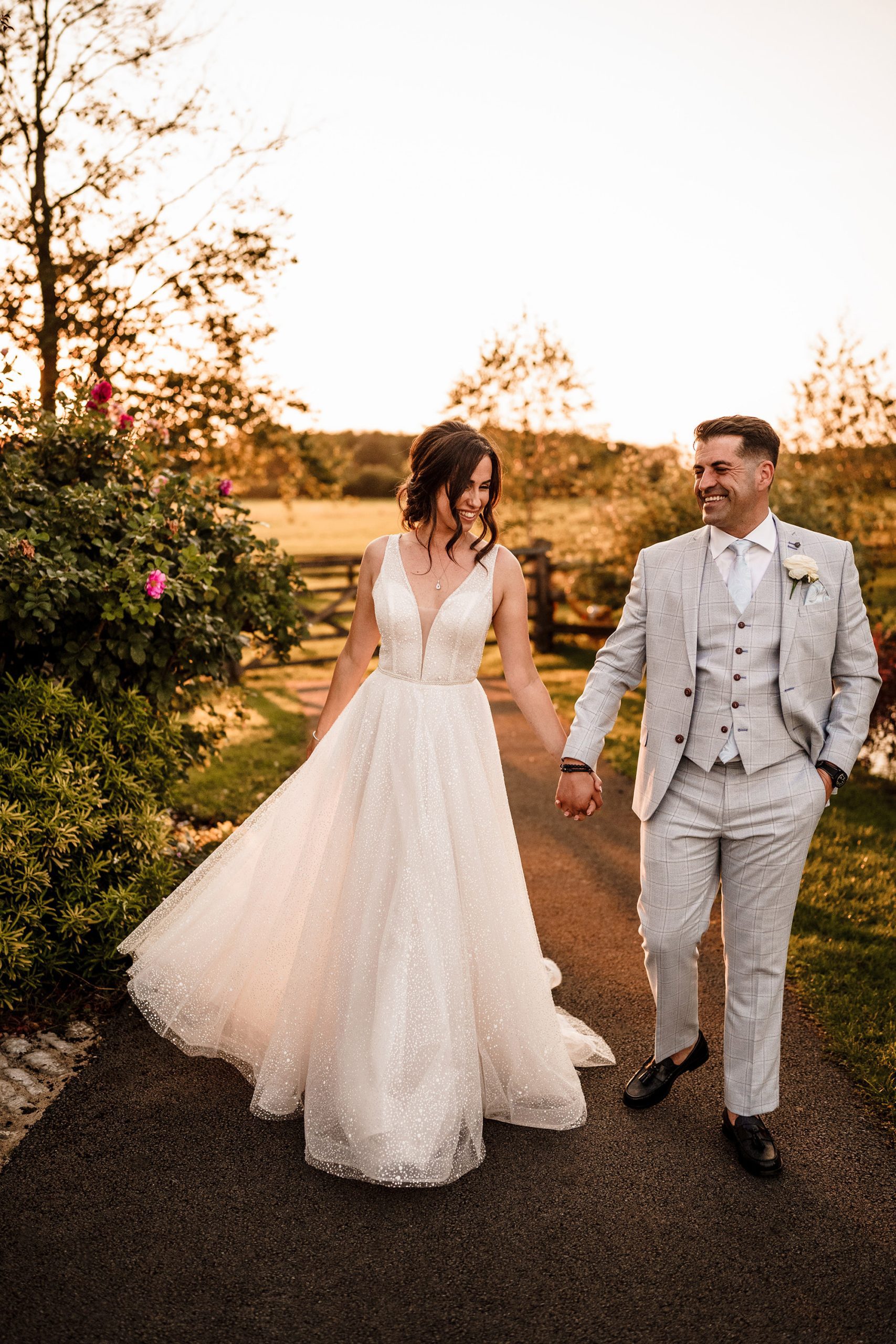 bride and groom holding hands in the grounds of Caswell House