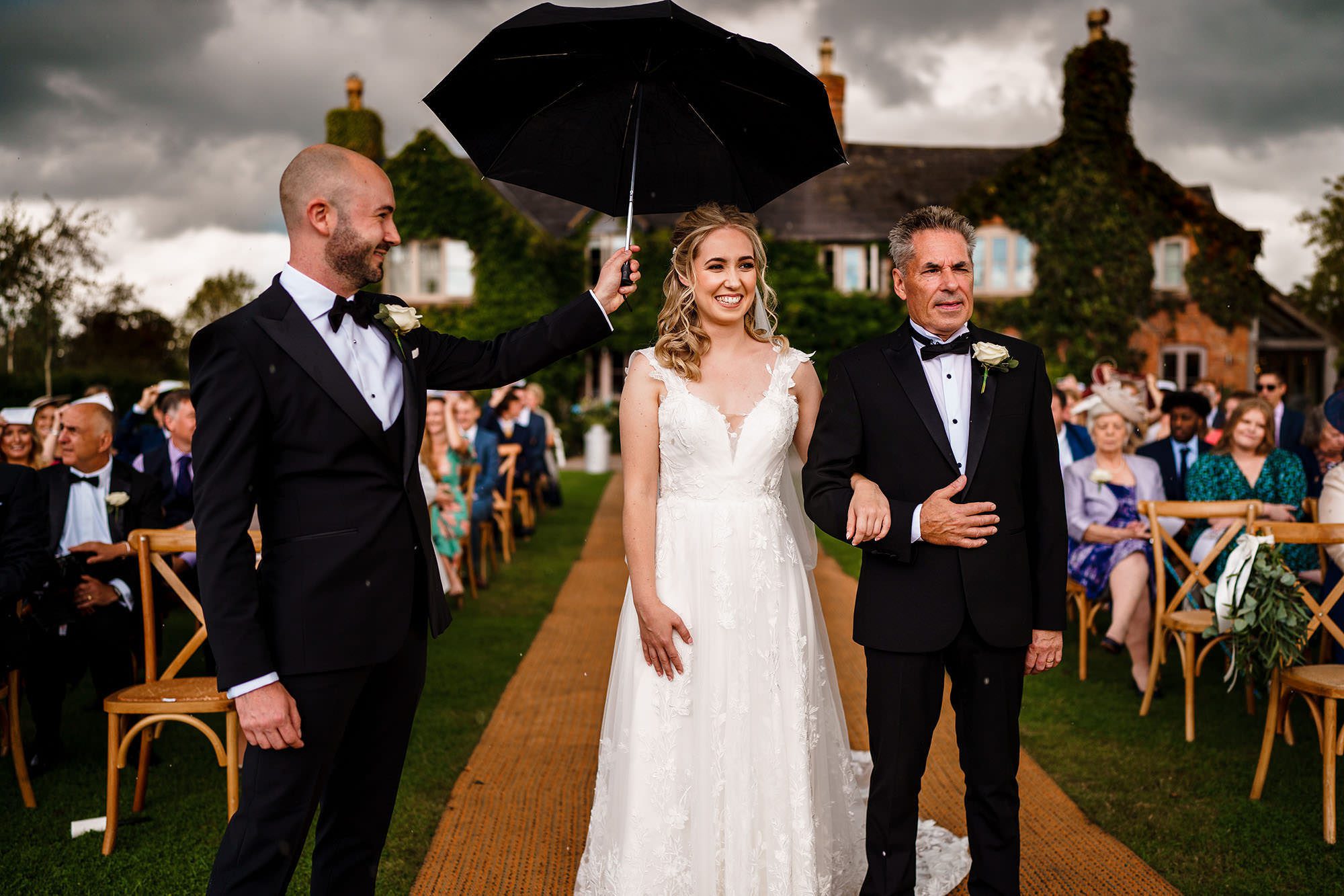 groom holds umbrella over brides head in the London
