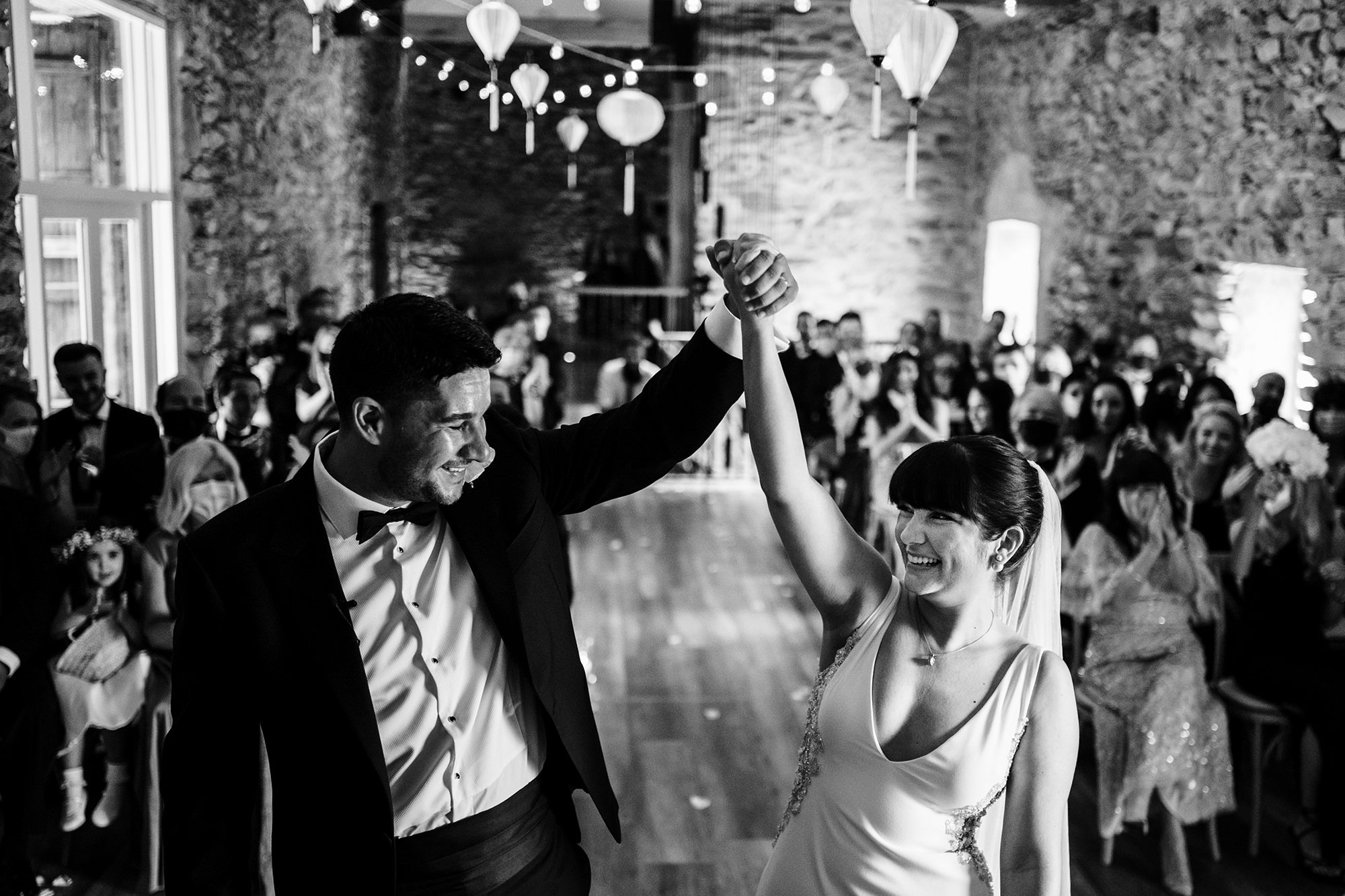 bride and groom celebrate inside London wedding barn