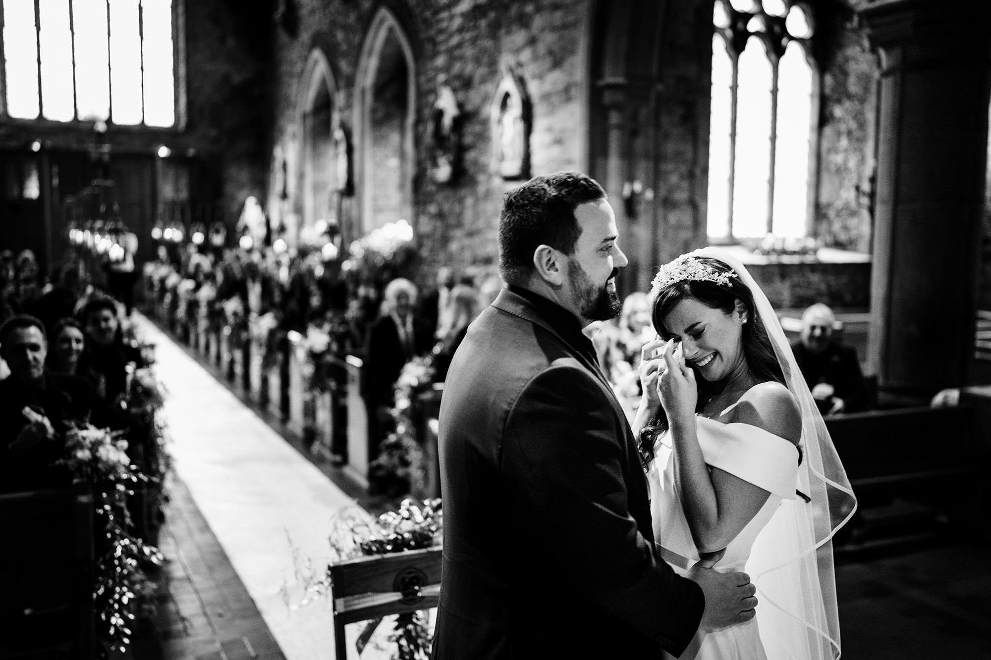 bride with groom at the end of aisle crying