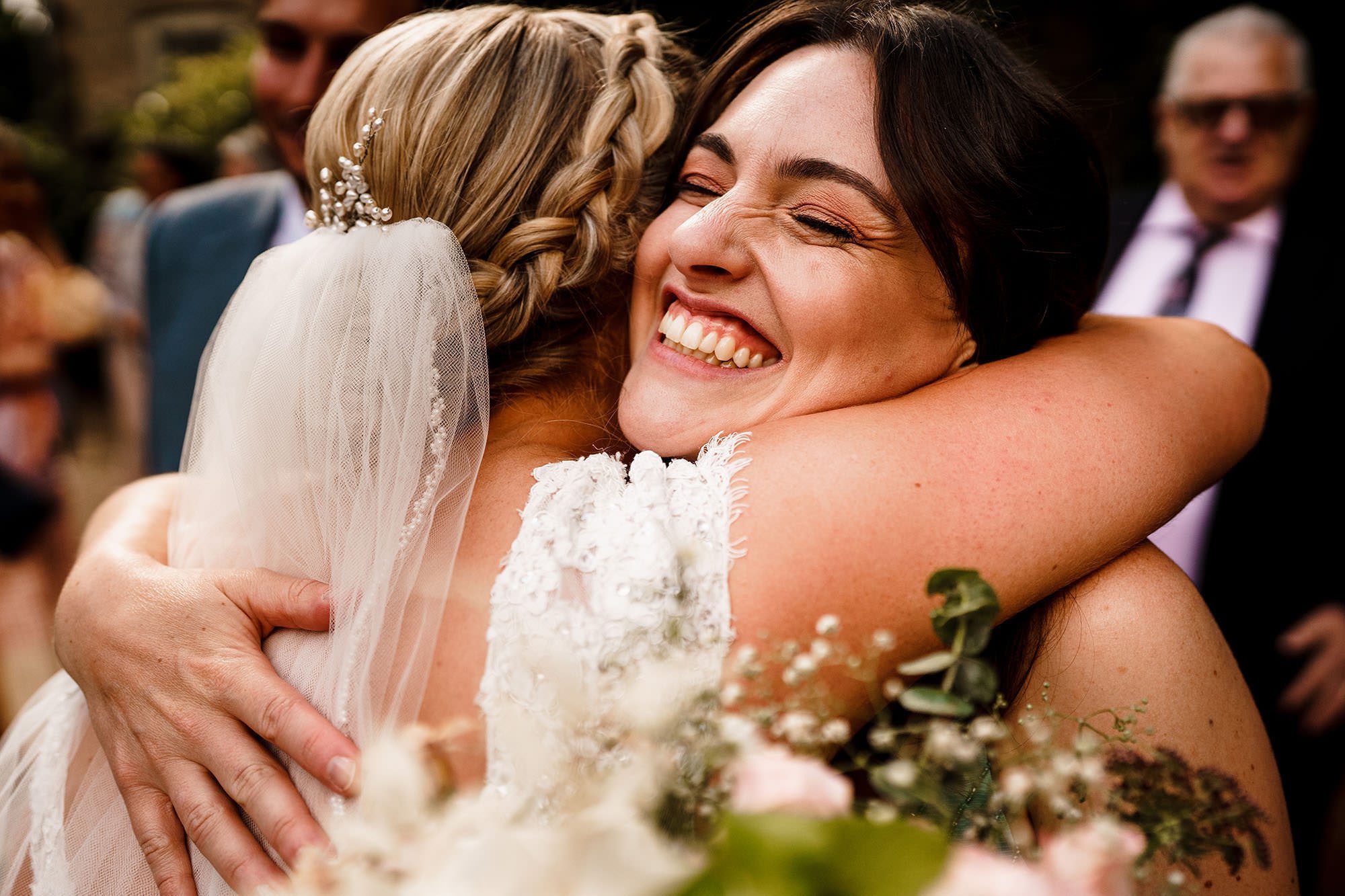 wedding guest smiles and hugs the bride