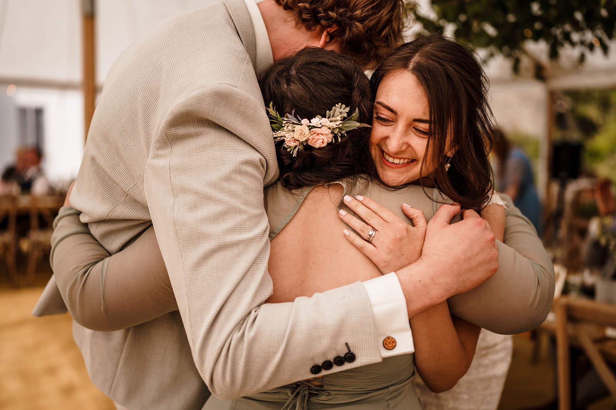 three people hug in side London Tipi