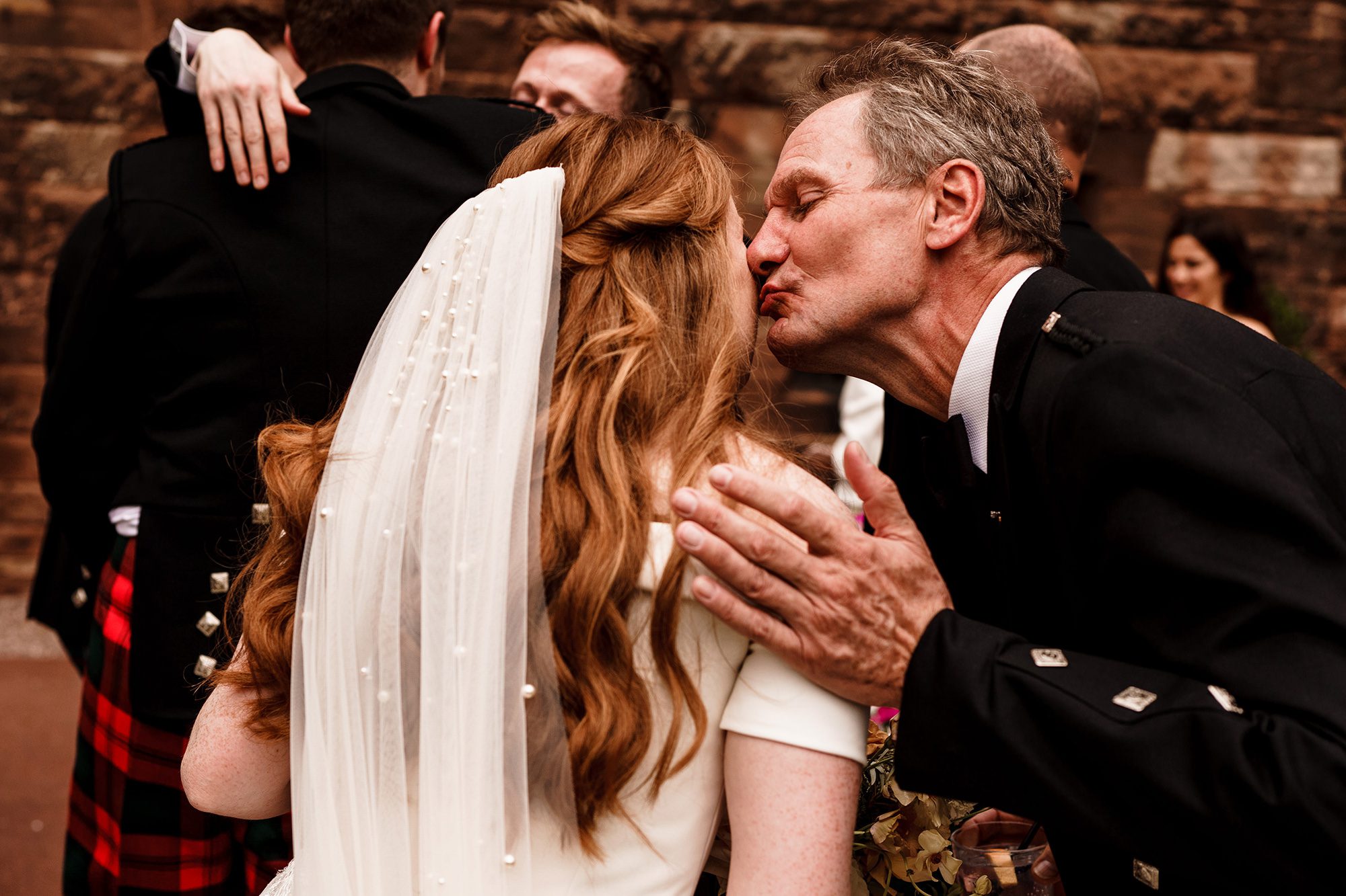 close relative kissed the bride on her cheek during drinks reception at peckfoton castle