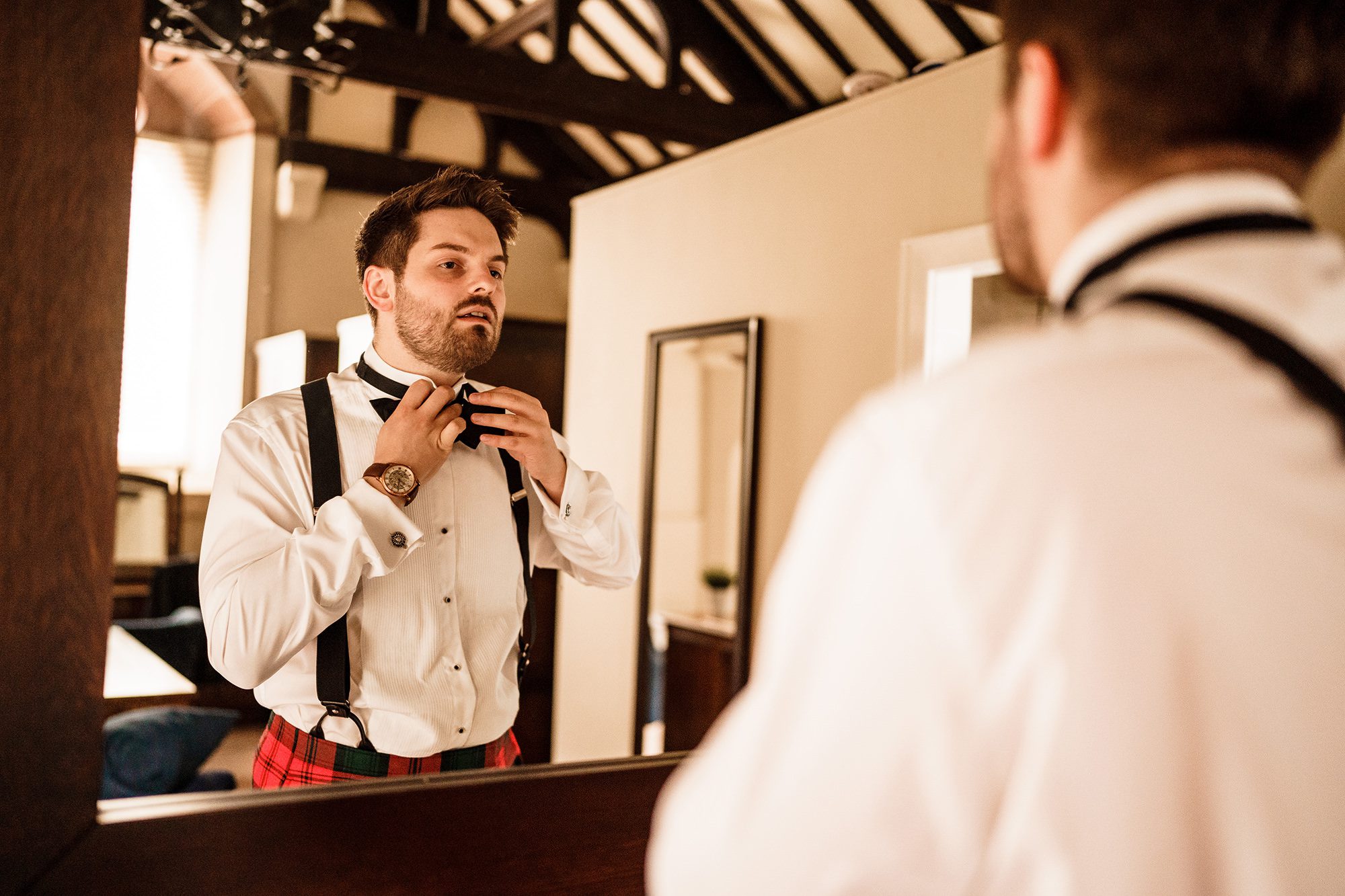 groom fastens his bow tie before his Cheshire wedding