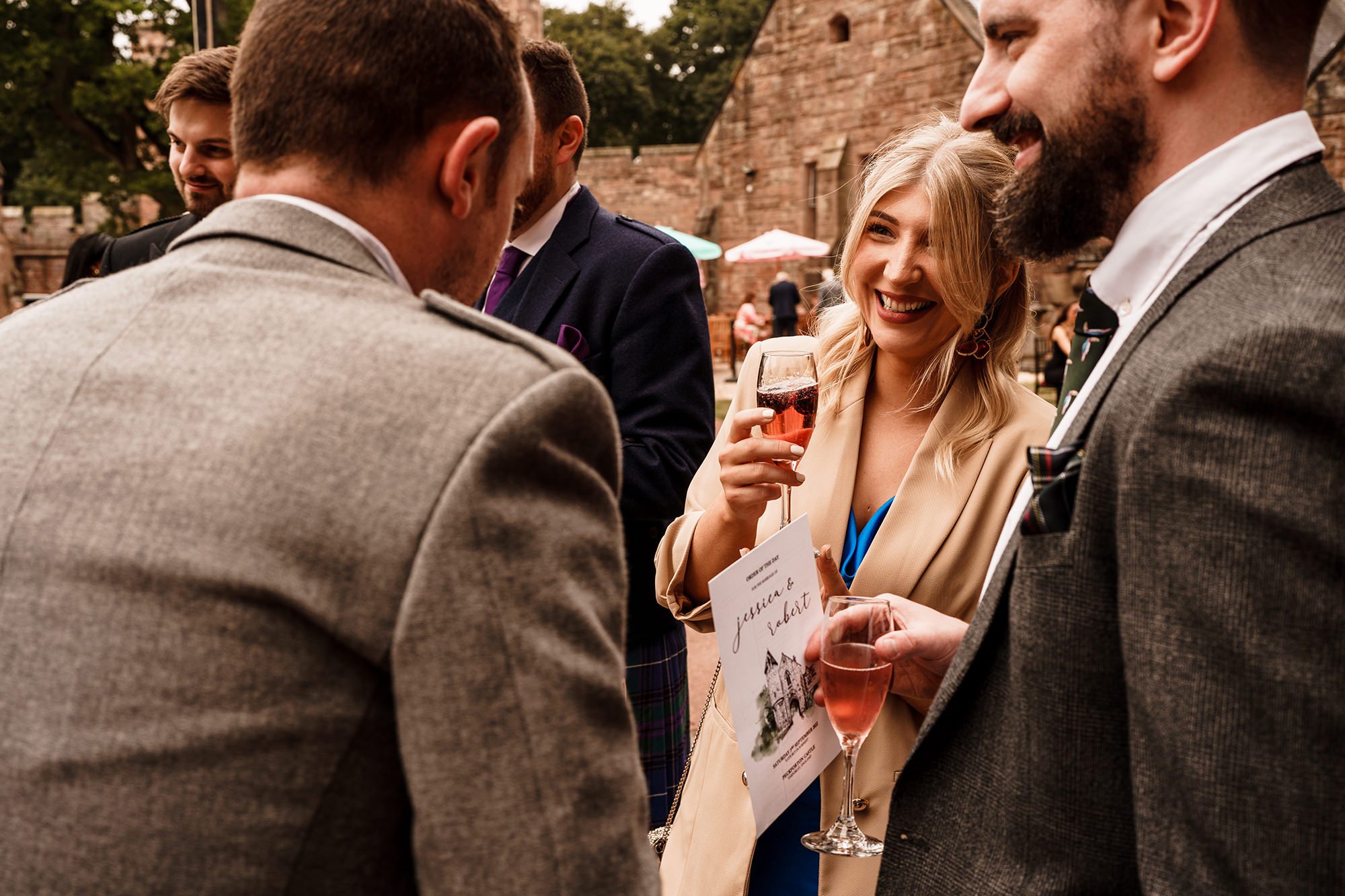 wedding guests chatting in the courtyard of peckfoton castle