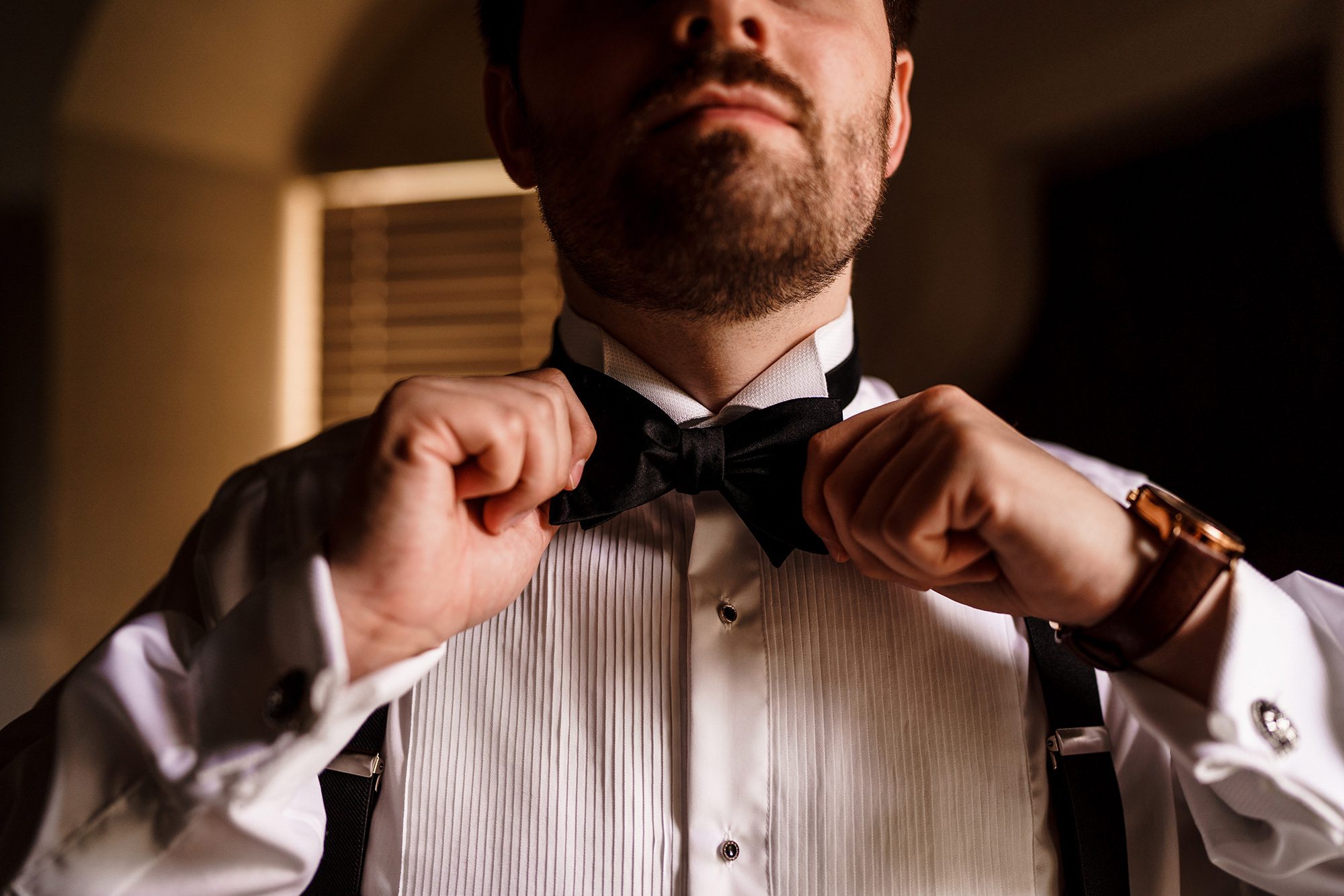 groom tightening his bow tie
