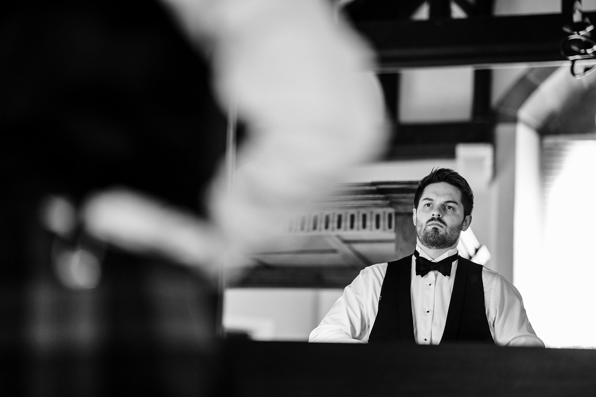 groom checks himself over in mirror at Peckforton Castle