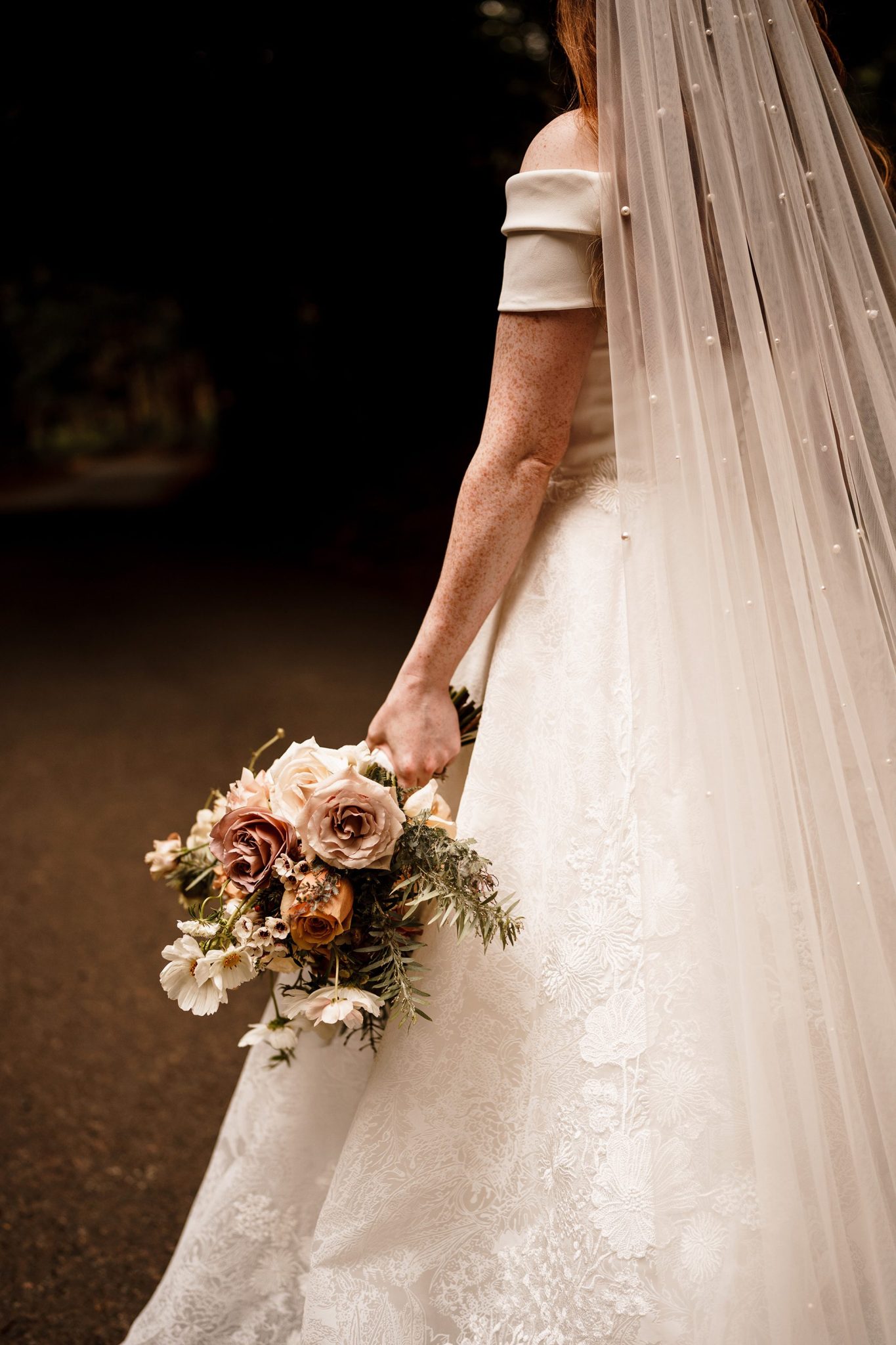 bridal bouquet in the hands of the bride outside Peckforton castle