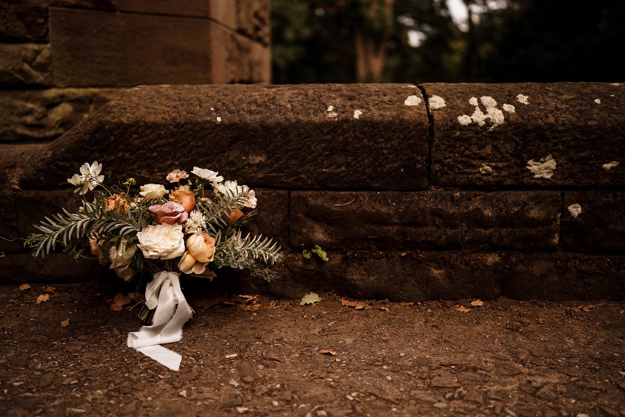 brides bouquet next to the walls of Peckforton Castle