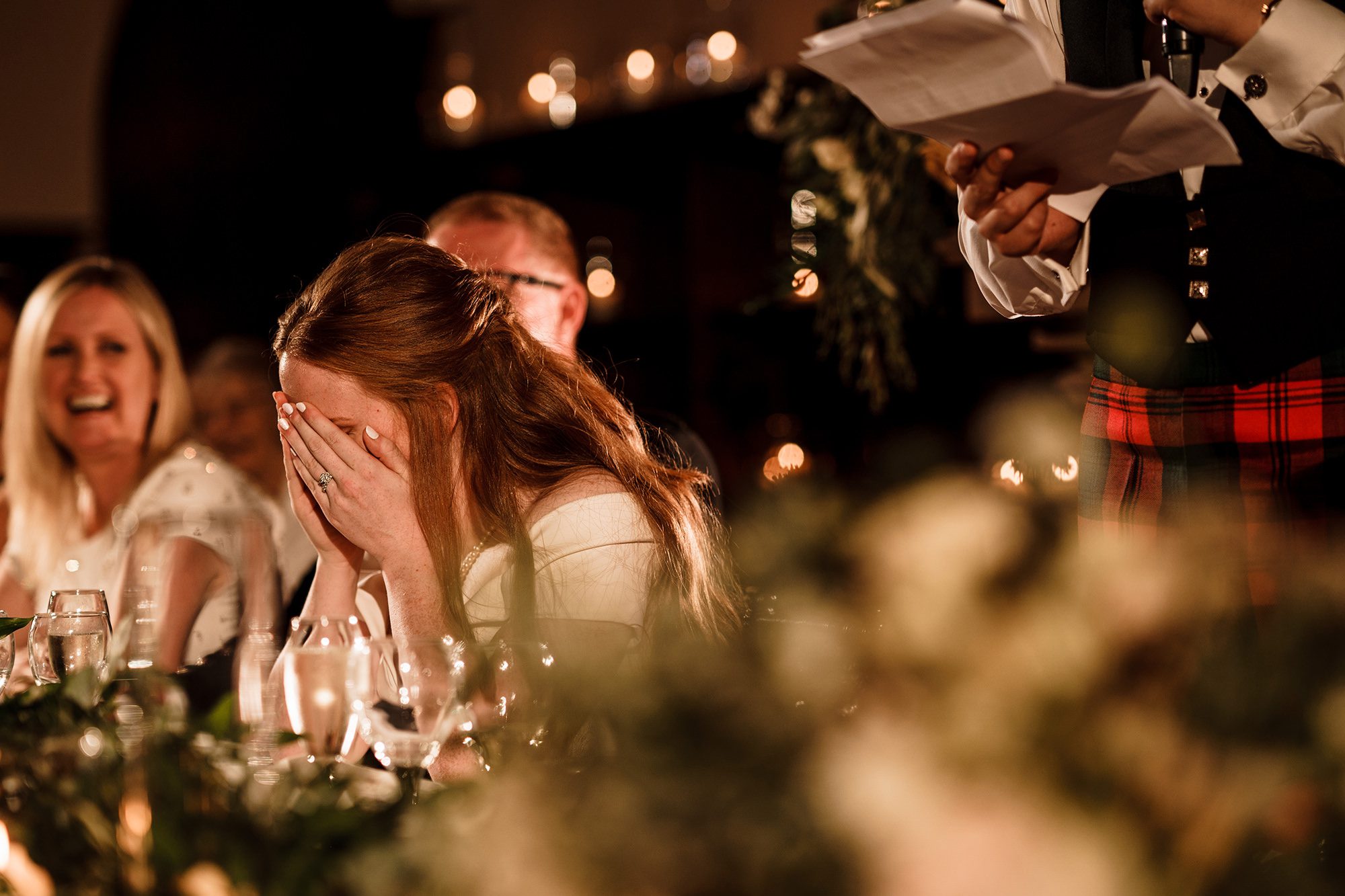 bride has face in her hands during speech from groom at peckfoton castle wedding