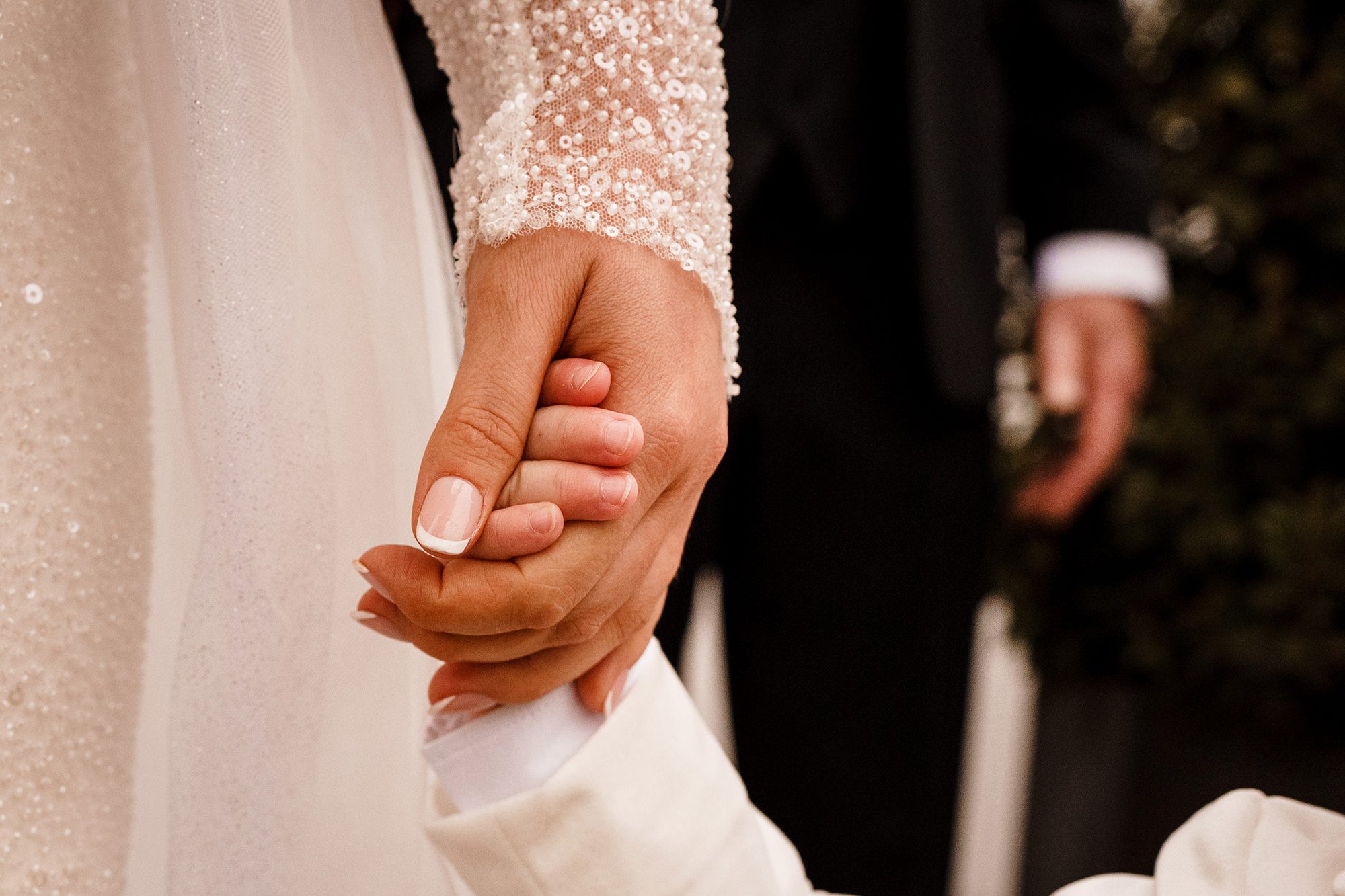 brides hand holding her sons hand
