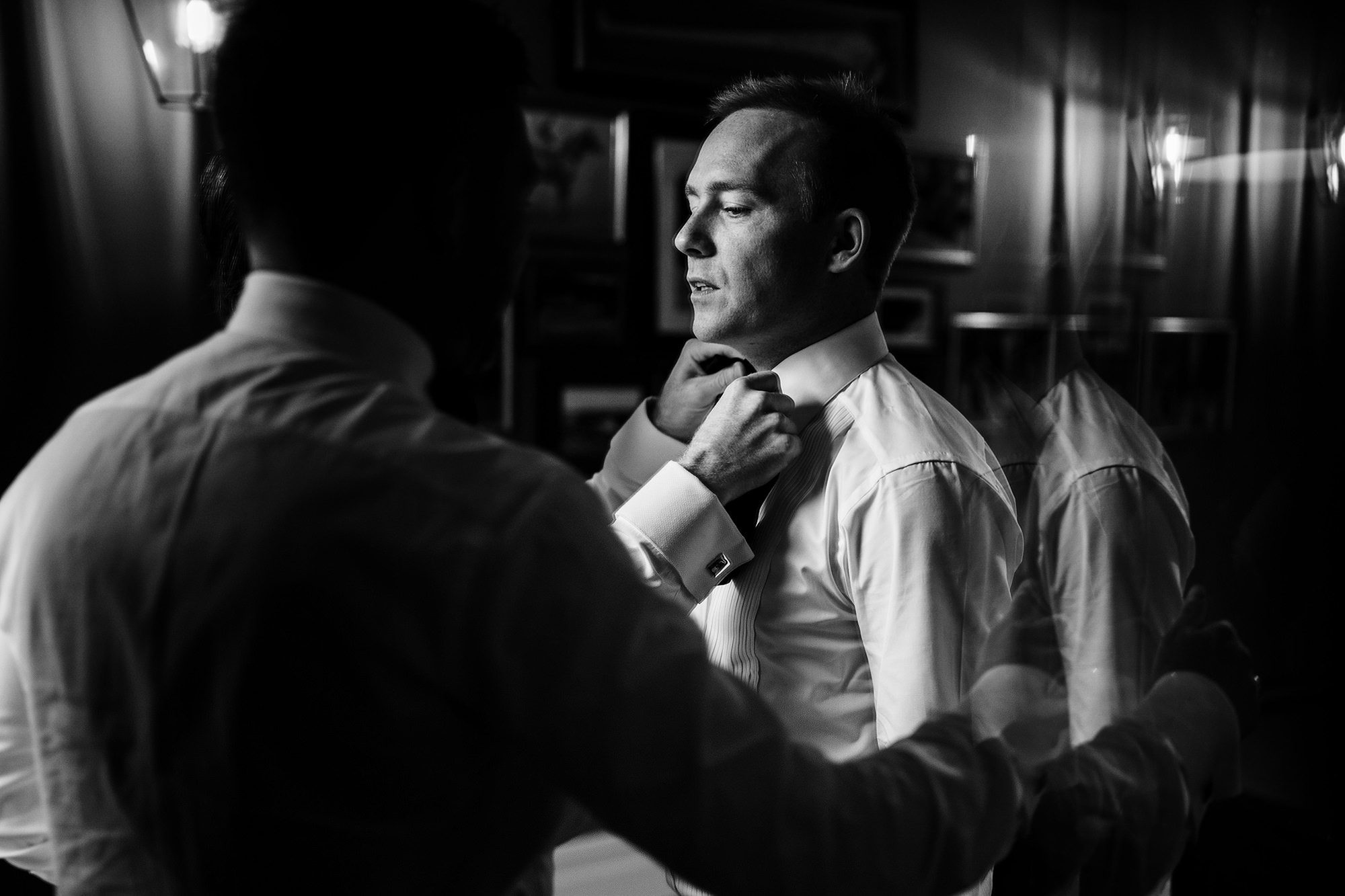 groomsmen put on groom tie at wedding gin Ireland