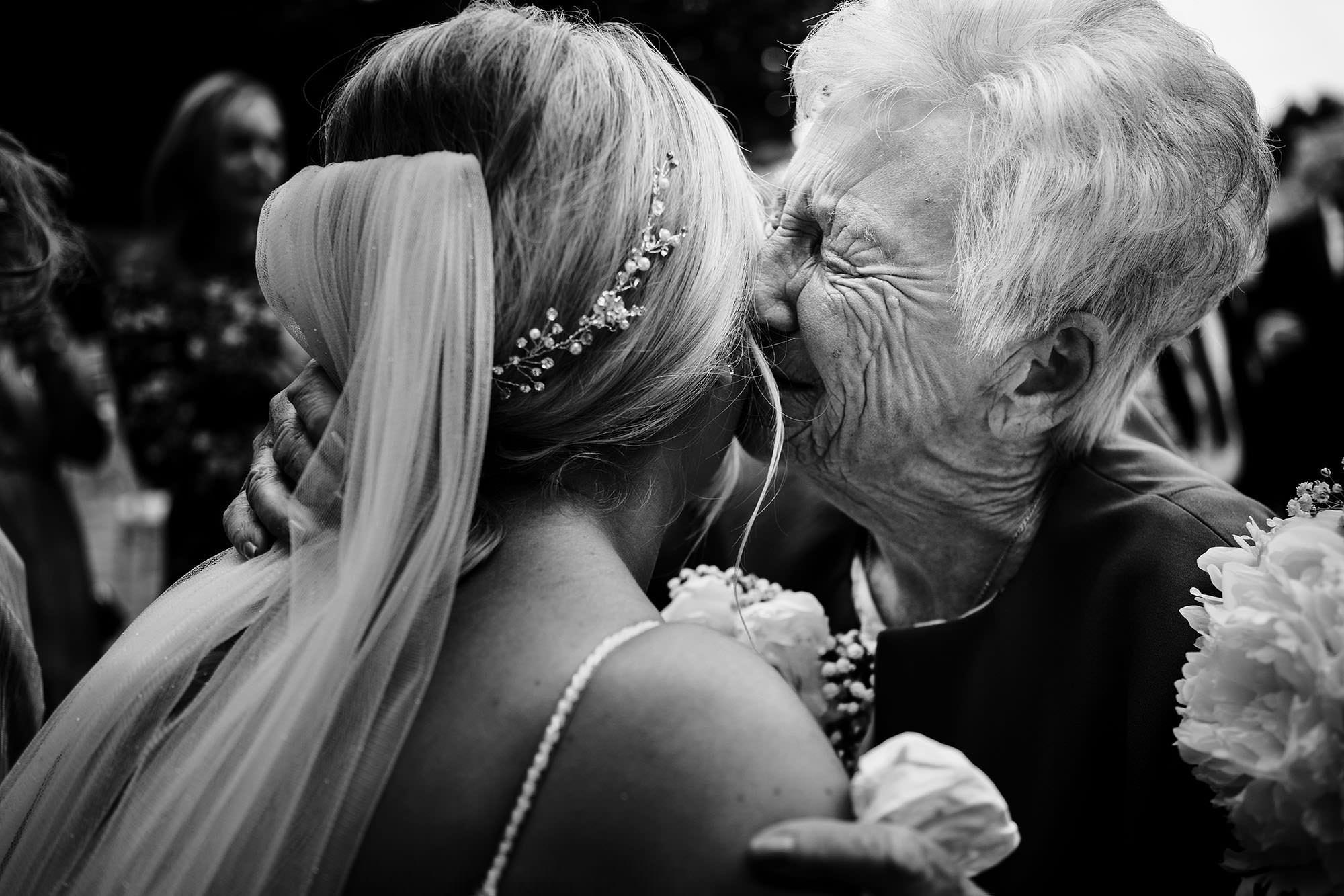 grandmother kisses bride on her cheek at Liverpool wedding