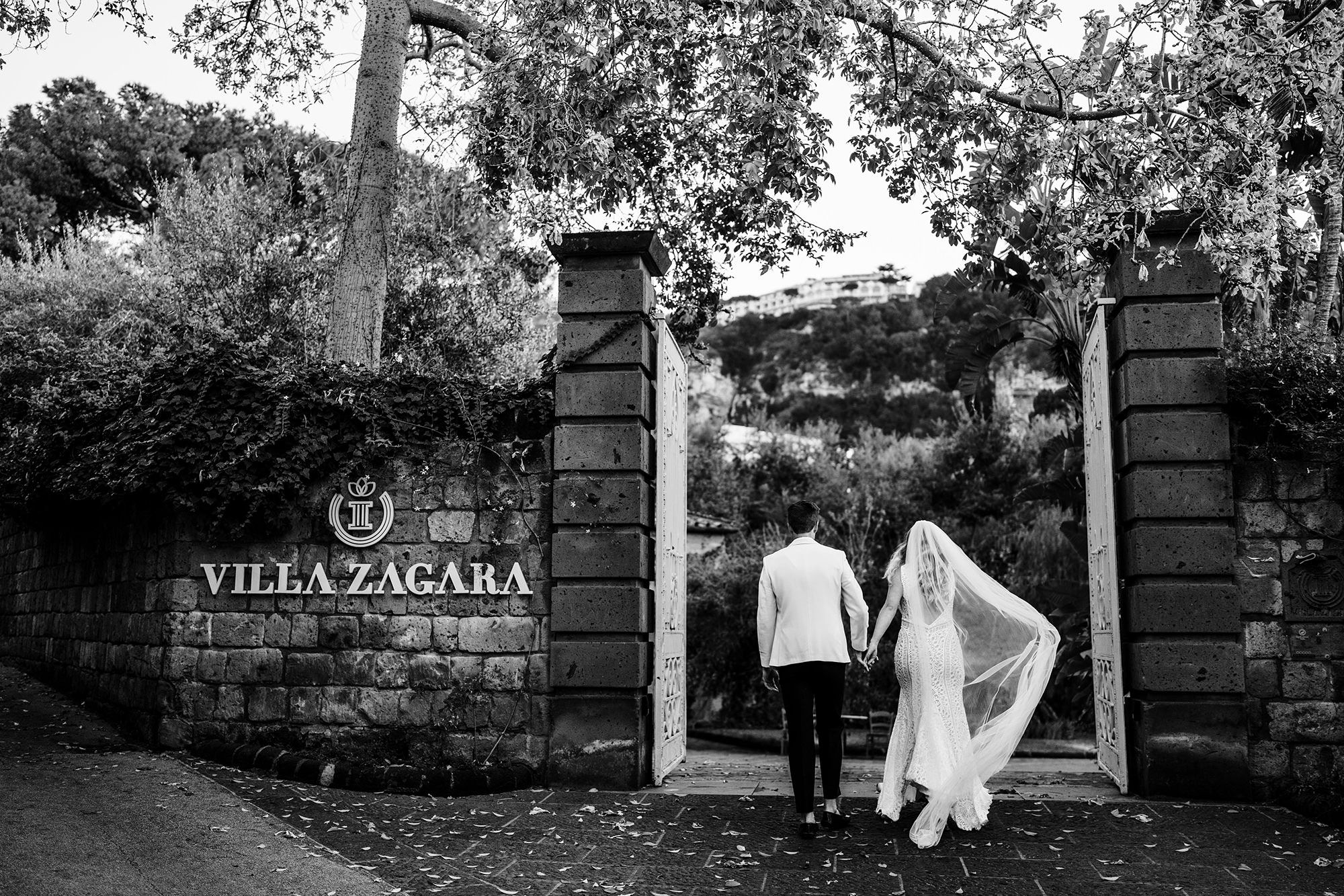 italy wedding of couple walking though a gate