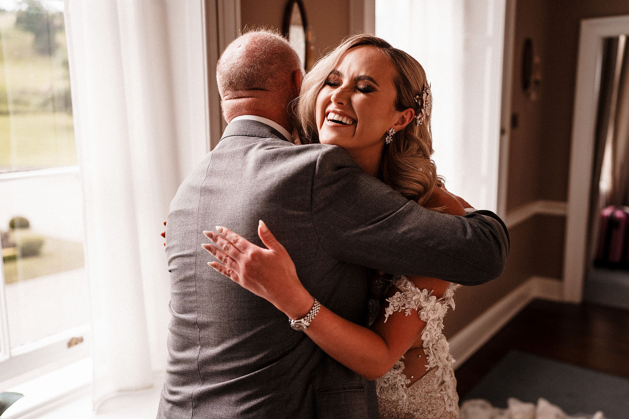 bride laughing and hugging dad at wedding