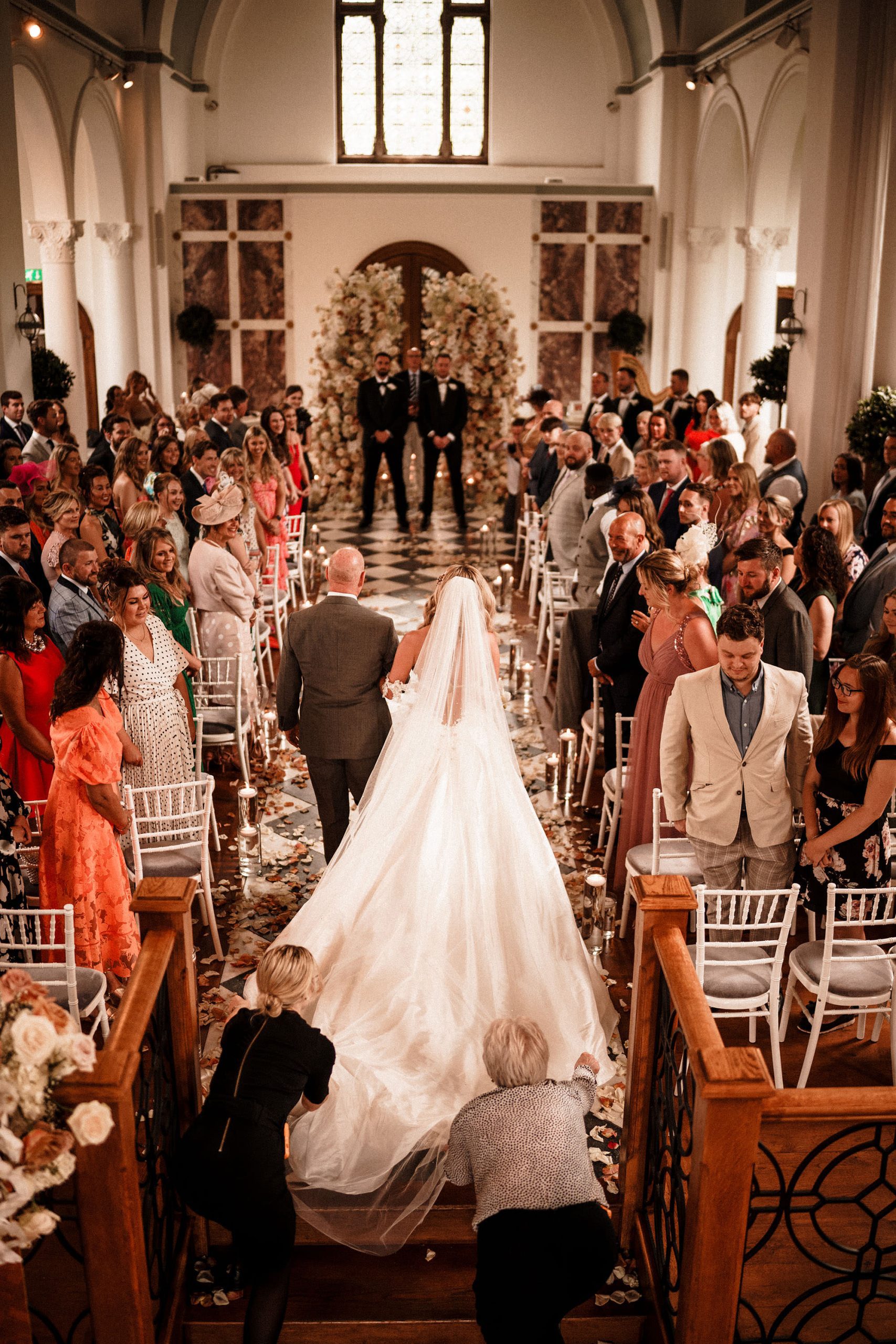 bride walking downthe aisle during luxury wedding at Hawkstone Hall