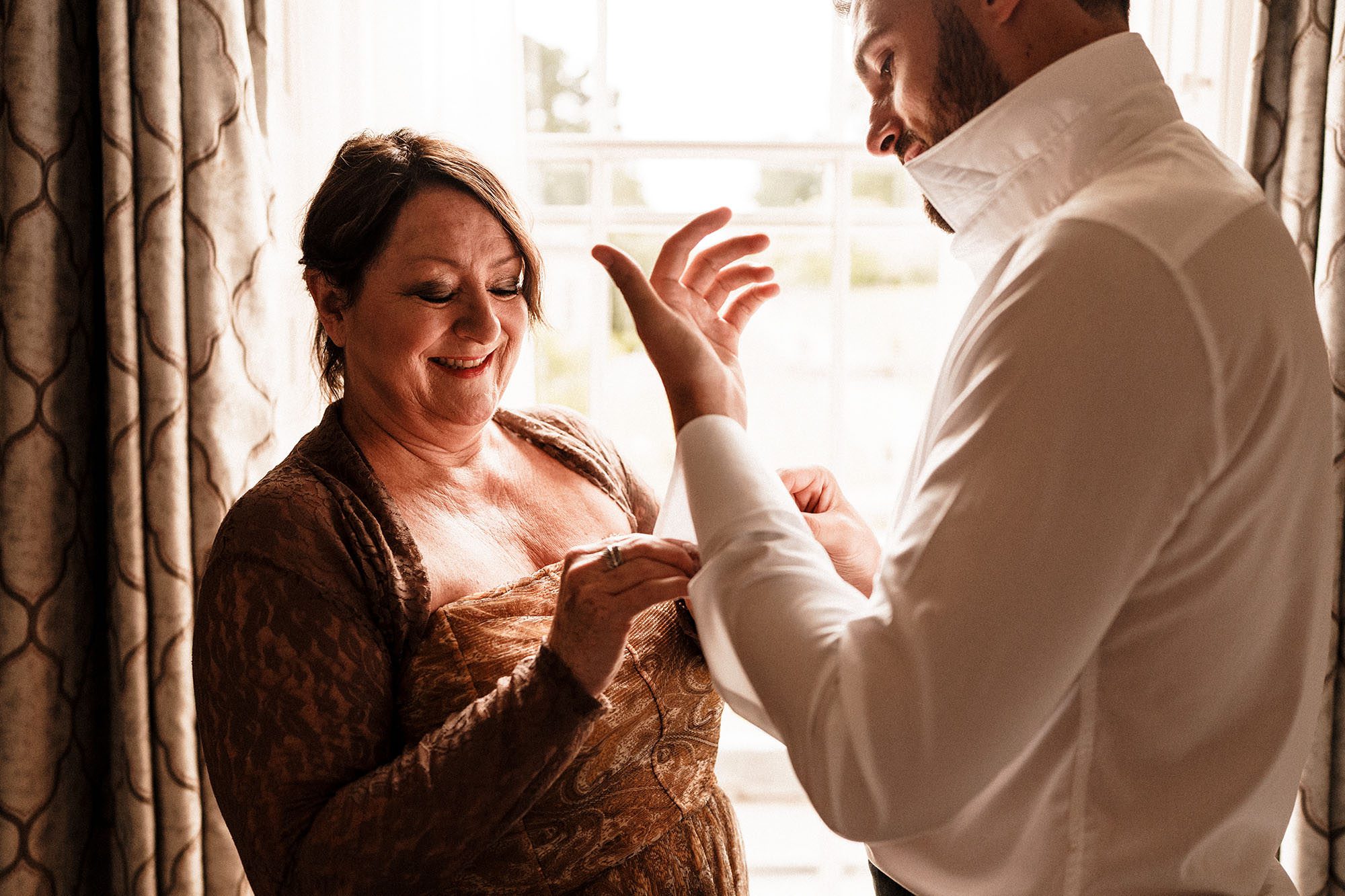 mother of the groom dressing her son at Hawkstone Hall
