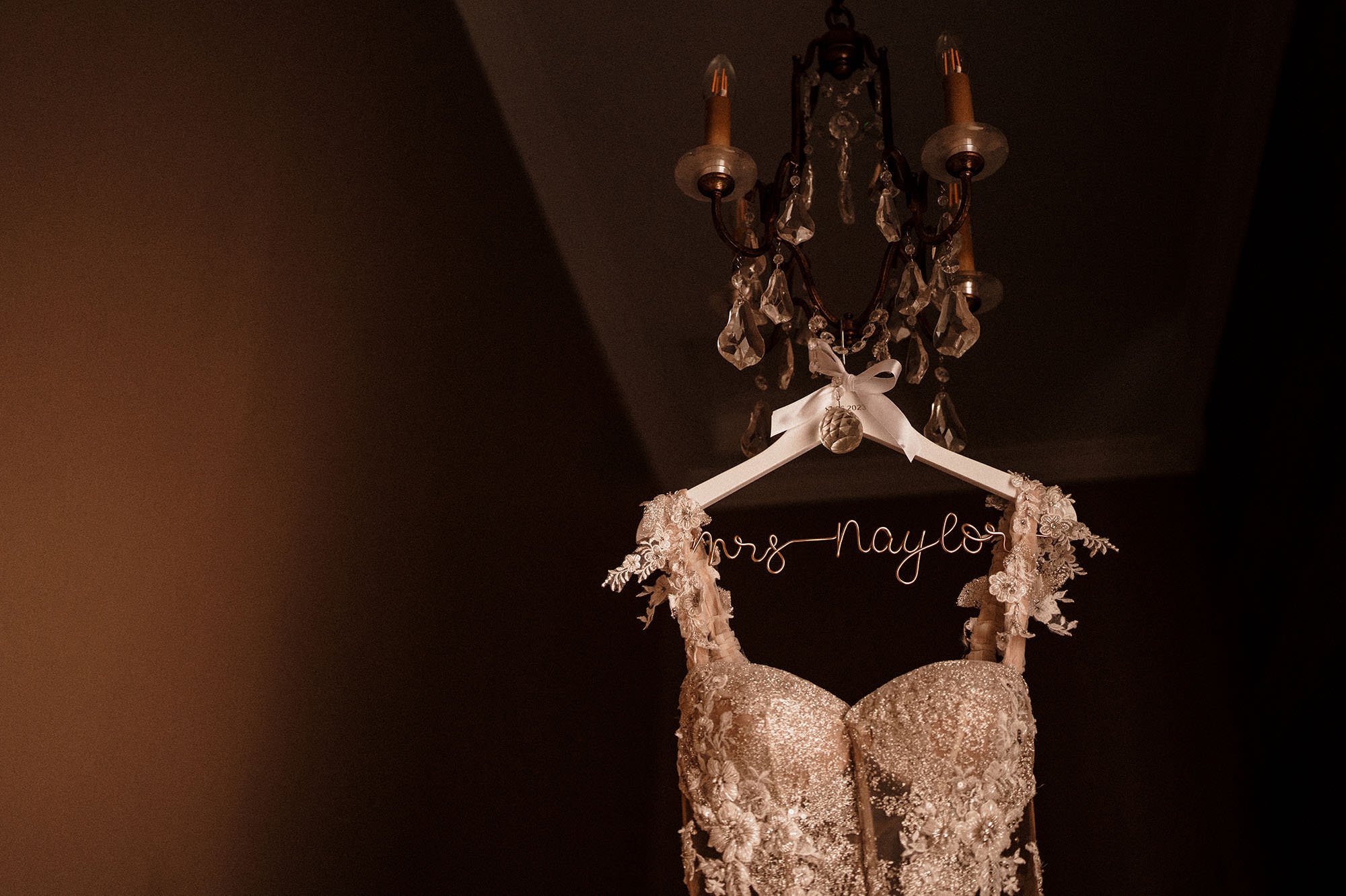 dress hanging from light at luxury wedding at Hawkstone Hall