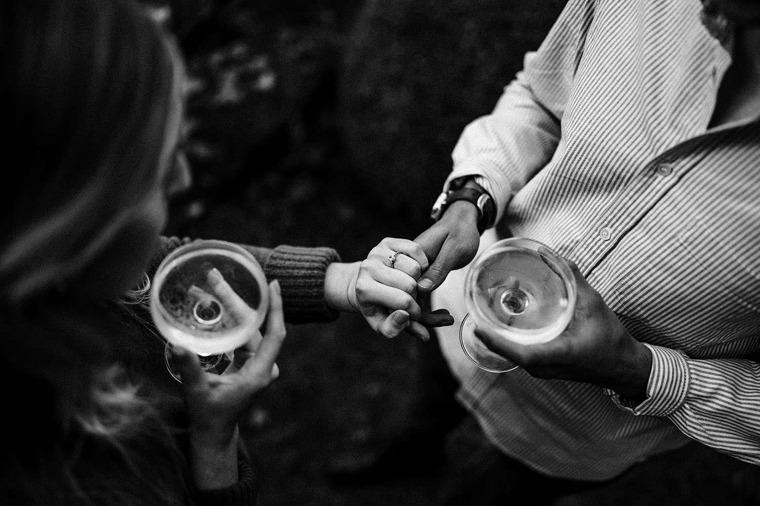 newly engaged couple looking at ring in the cotswolds