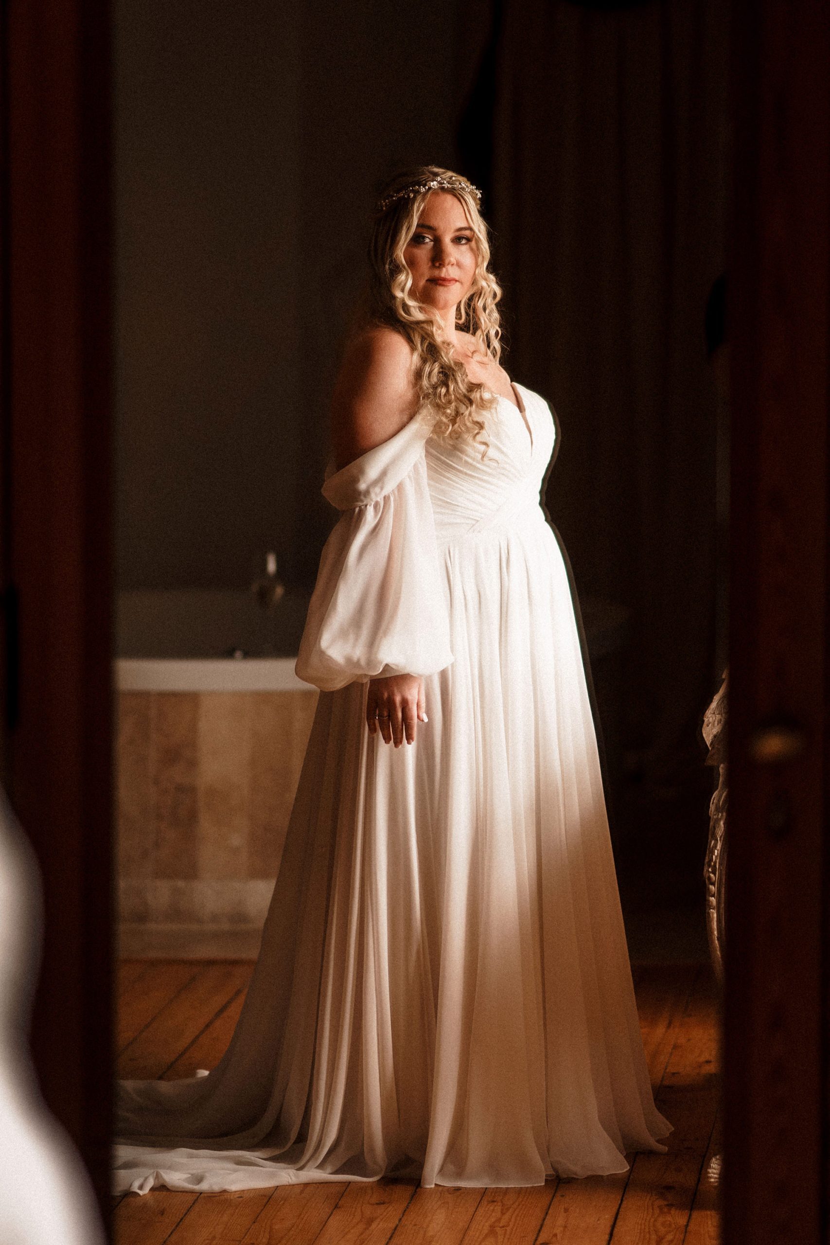 bride elegantly looking at her dress for her Achnagairn Castle wedding