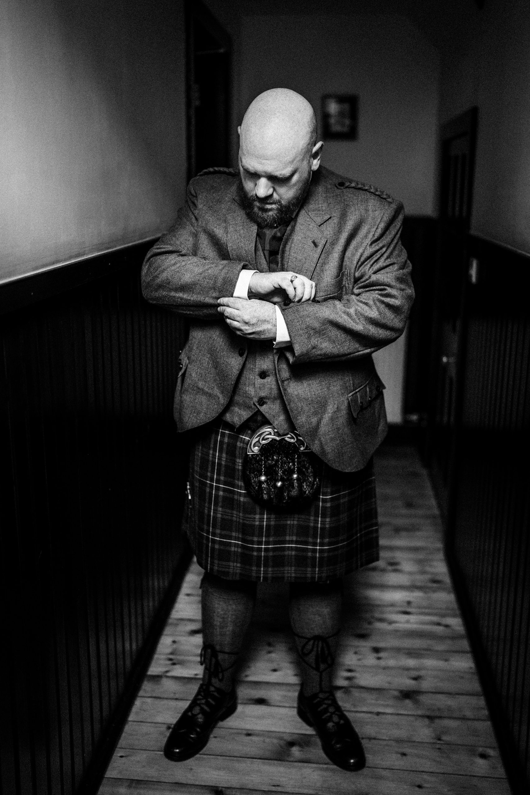 groom adjusting his suit prior to his Achnagairn Castle wedding