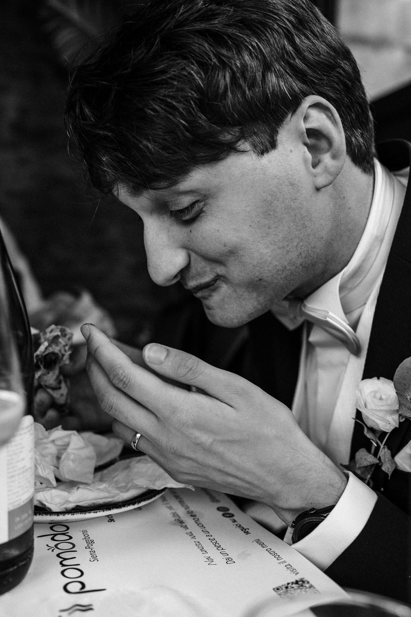 editorial wedding photogrpahers image of a groom in the moment eating pizza