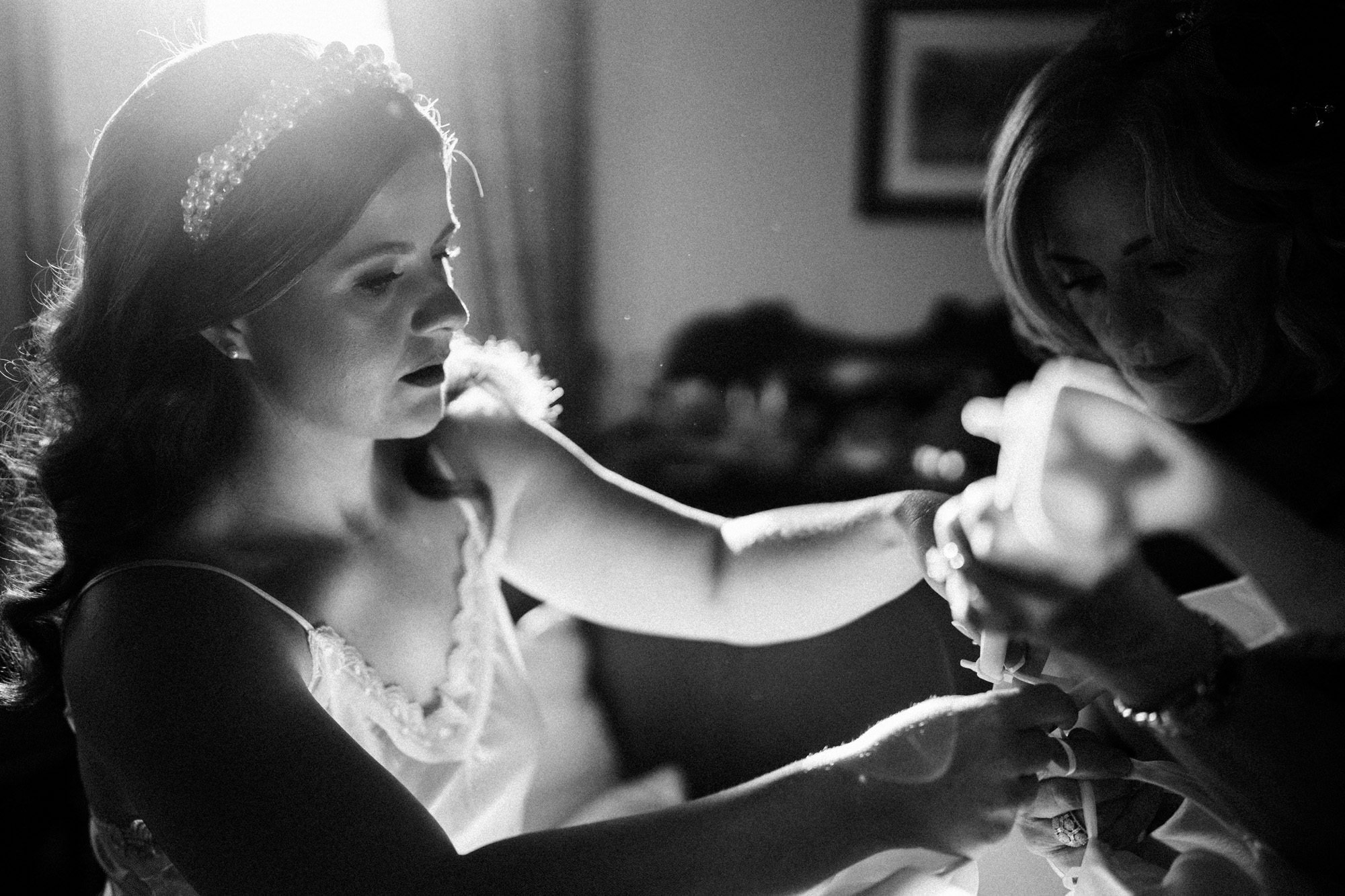mother of the bride helps mount falcon bride with her wedding dress